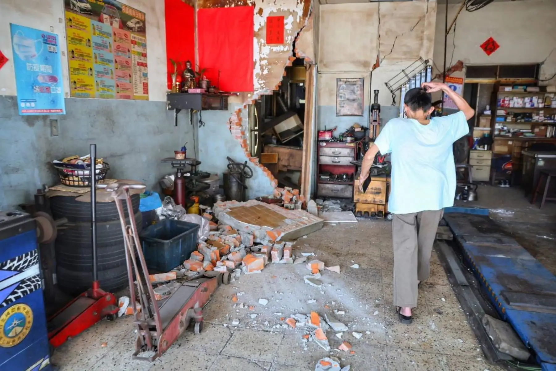 Un hombre reacciona después de que una pared de ladrillos de una casa se derrumbara en Taipei, después de que un gran terremoto azotara el este de Taiwán. Foto: AFP