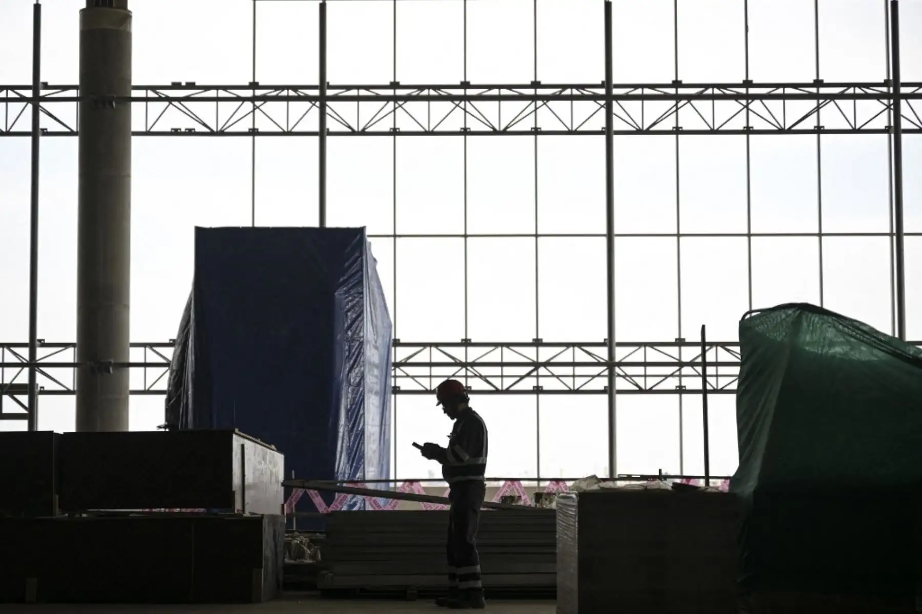 Un trabajador de la construcción trabaja en las nuevas instalaciones del Aeropuerto Internacional Jorge Chávez en Lima. Foto: AFP