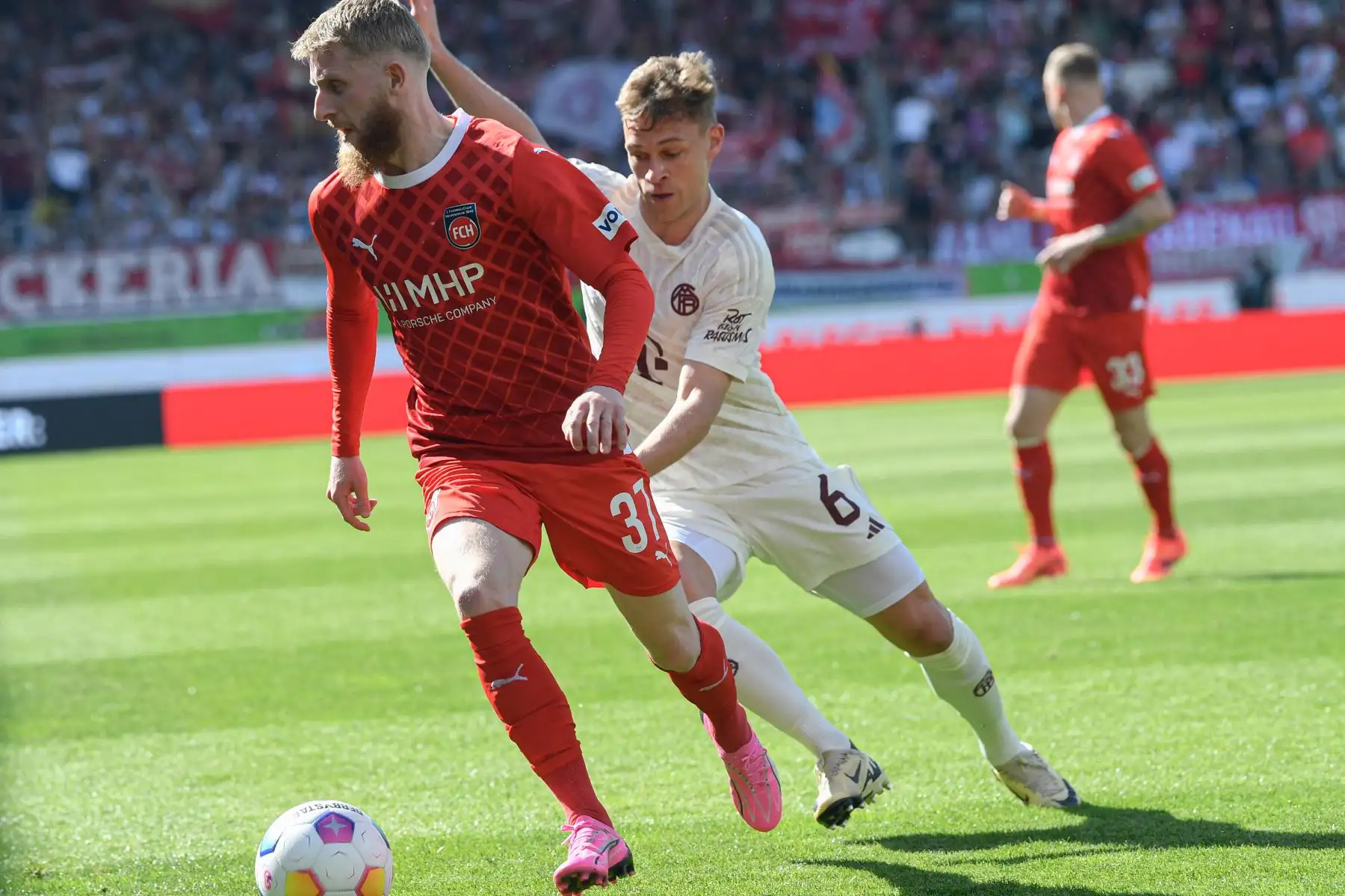 El delantero alemán de Heidenheim #37 Jan-Niklas Beste y el centrocampista alemán del Bayern Munich #06 Joshua Kimmich compiten por el balón durante el partido de fútbol de la Bundesliga alemana de primera división 1 FC Heidenheim contra FC Bayern Munich en Heidenheim, suroeste de Alemania. Foto: AFP