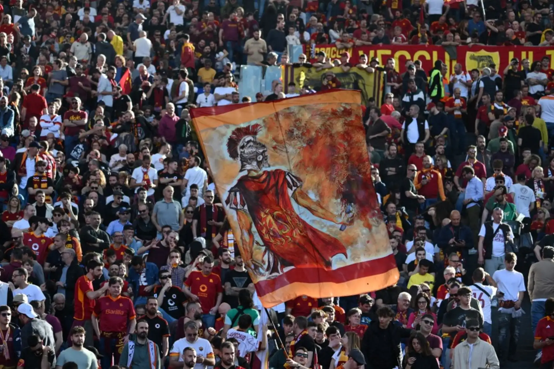 Los seguidores de la Roma ondean banderas antes del partido de fútbol de la Serie A italiana entre la AS Roma y la Lazio el 6 de abril de 2024 en el estadio olímpico de Roma. Foto: AFP
