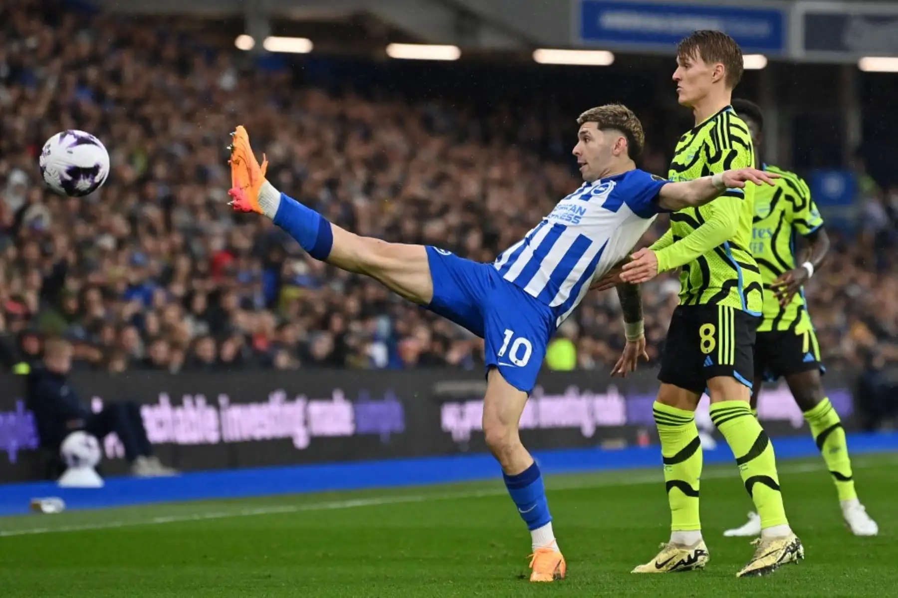 El delantero paraguayo de Brighton #10 Julio Enciso (C) compite con el centrocampista noruego del Arsenal #08 Martin Odegaard (R) durante el partido de fútbol de la Liga Premier inglesa entre Brighton y Hove Albion y el Arsenal en el American Express Community Stadium en Brighton, sur de Inglaterra. Foto: AFP