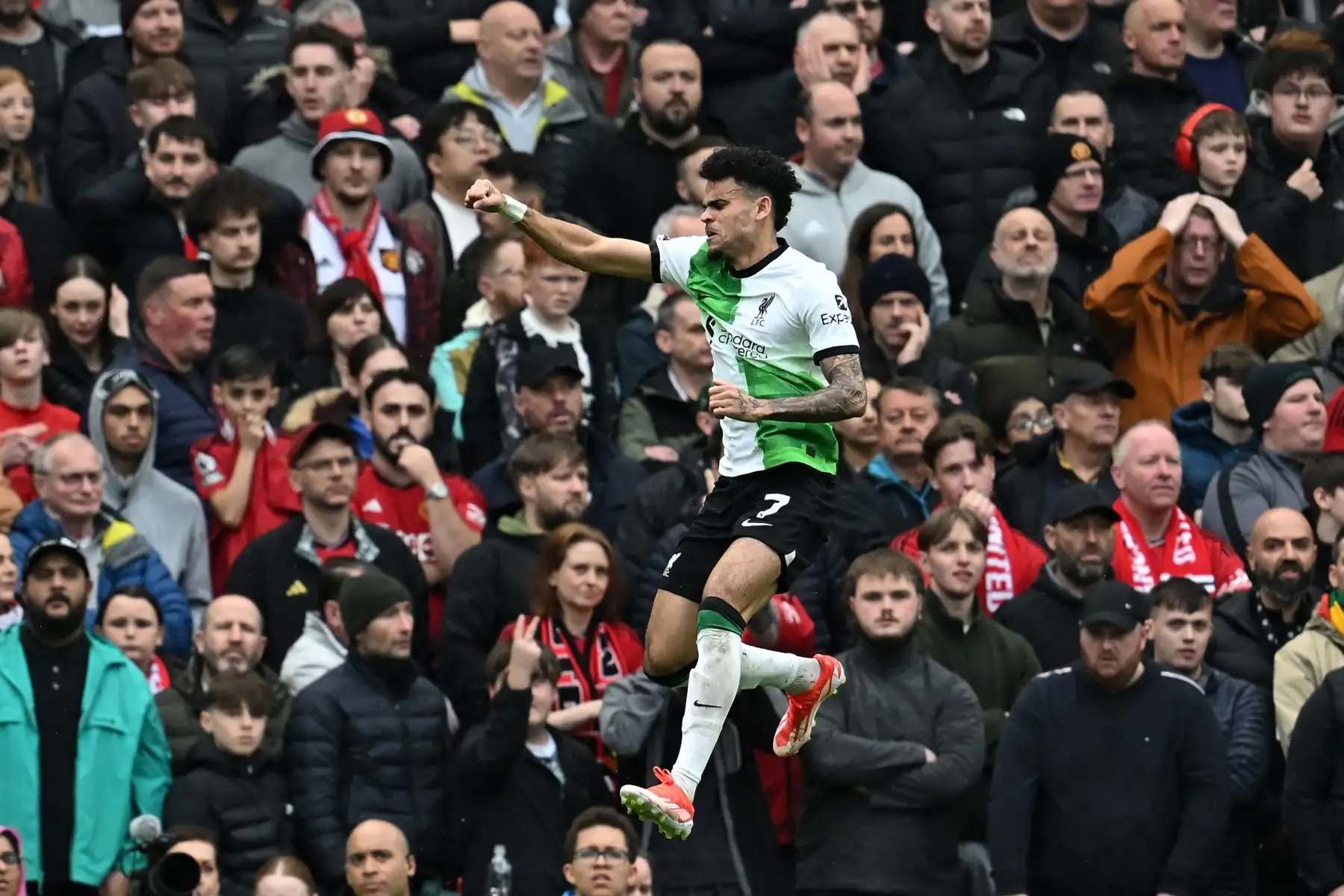 El centrocampista colombiano del Liverpool, Luis Díaz, celebra tras marcar el gol inicial frente a los aficionados del United durante el partido de fútbol de la Premier League inglesa entre Manchester United y Liverpool. Foto: ANDINA/AFP