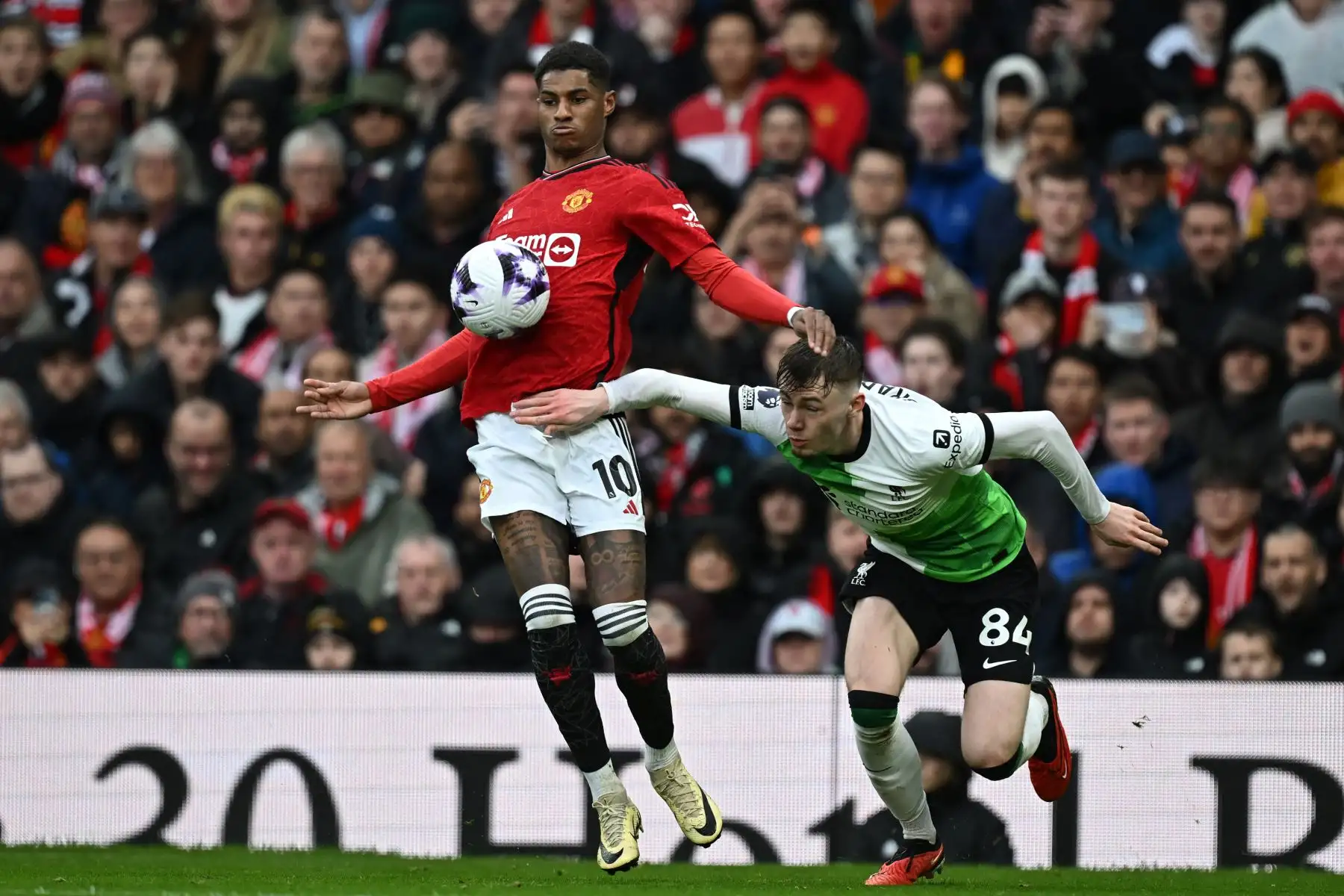 El delantero inglés del Manchester United Marcus Rashford compite con el defensor norirlandés del Liverpool Conor Bradley durante el partido de fútbol de la Premier League inglesa entre Manchester United y Liverpool. Foto: ANDINA/AFP