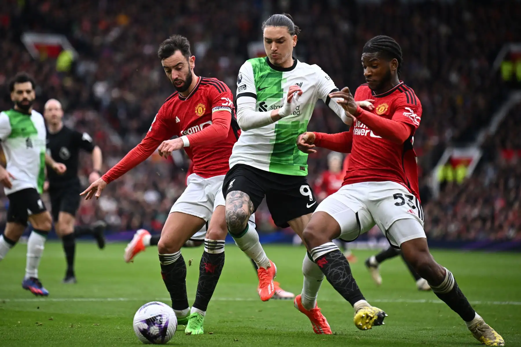 El delantero uruguayo del Liverpool  Darwin Núñez  compite con el mediocampista portugués del Manchester United Bruno Fernandes  y el defensor francés nacido en Conoglese del Manchester United  Willy Kambwala durante el partido de fútbol de la Premier League inglesa entre Manchester United y Liverpool. Foto: ANDINA/ AFP