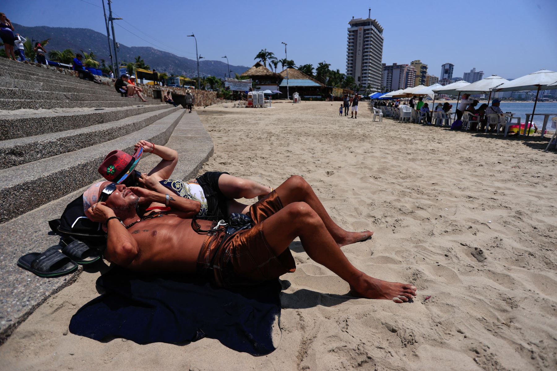 Personas observan un eclipse solar este lunes, en el balneario de Acapulco (México). El eclipse total de Norteamérica comenzó este lunes a apreciarse en la ciudad mexicana de Mazatlán, la primera urbe del continente en atestiguar el fenómeno y también en la que tendrá mayor duración, 4 minutos con 20 segundos. 
Foto: EFE