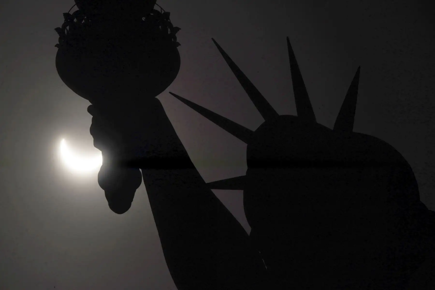 Un eclipse solar parcial cruza el cielo cerca de la Corona de la Estatua de la Libertad en Liberty Island el 8 de abril de 2024, en la ciudad de Nueva York, EE.UU. Foto: AFP