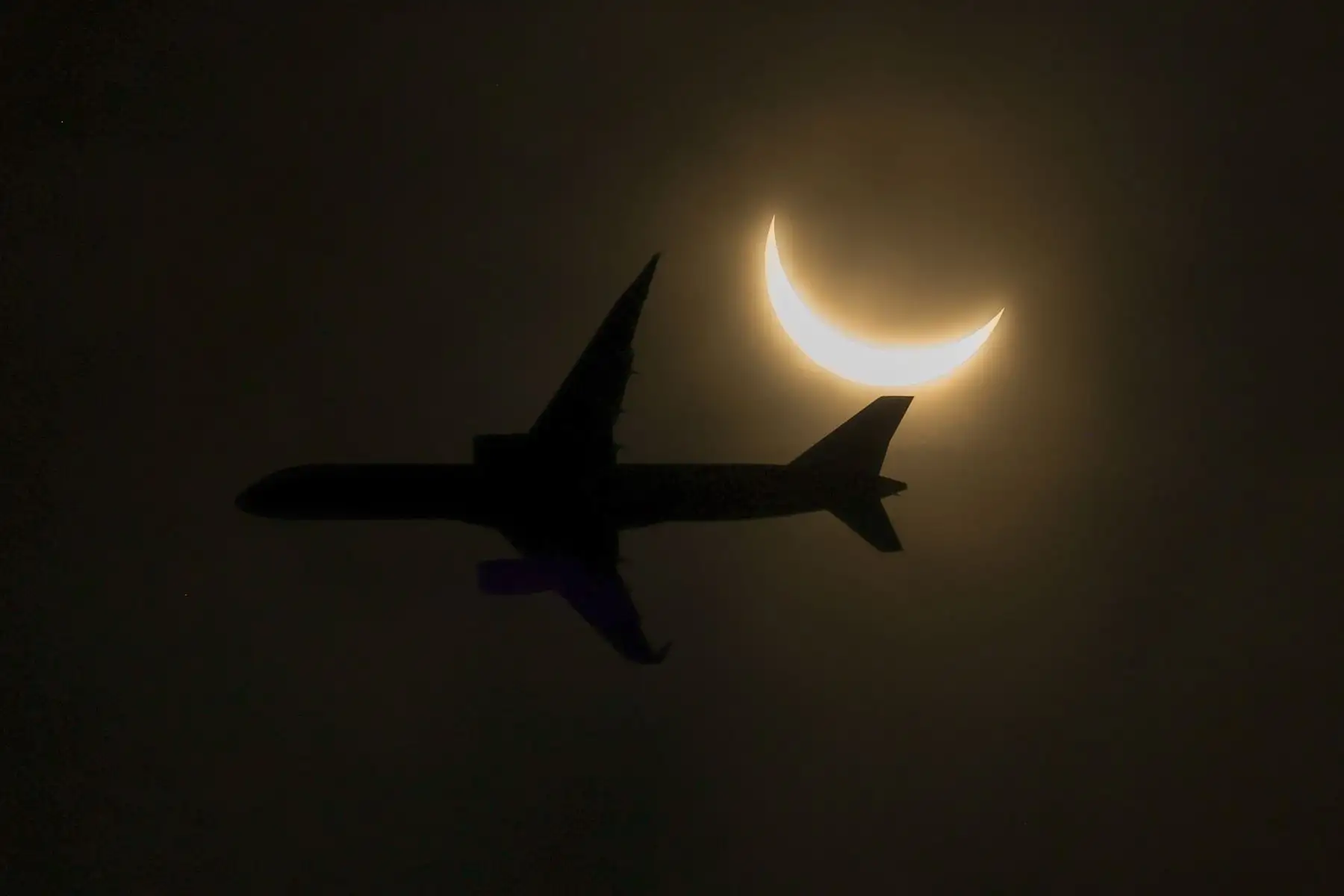 Un avión vuela en la trayectoria de un eclipse solar parcial visto el 8 de abril de 2024 en Glen Rock, Nueva Jersey, EE.UU. Foto: AFP