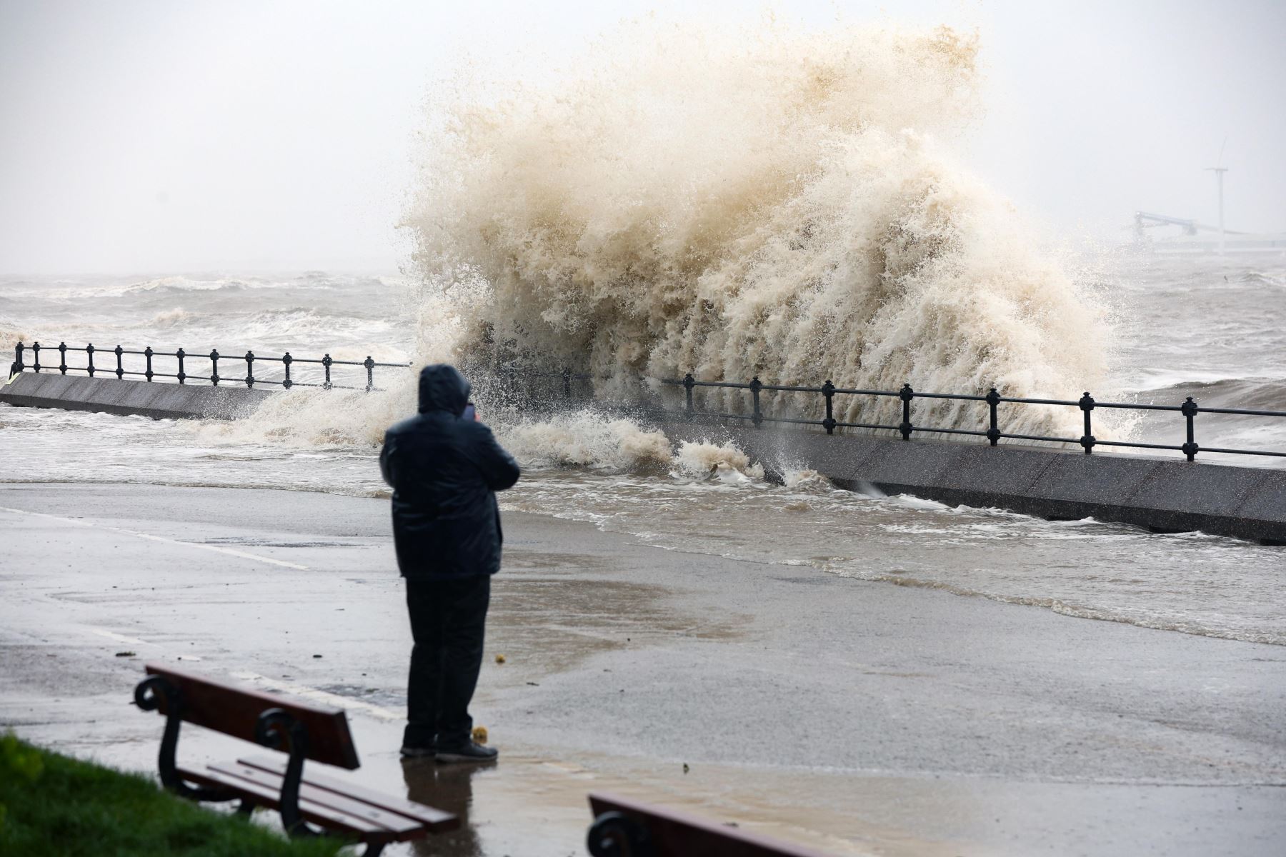 Una persona toma fotografías de olas rompiendo contra el malecón en New Brighton, Gran Bretaña, el 9 de abril de 2024. La Oficina Meteorológica del Reino Unido ha emitido advertencias meteorológicas amarillas por viento y lluvia, ya que la tormenta Pierrick trae fuertes vientos y fuertes lluvias a las zonas costeras. Foto: EFE