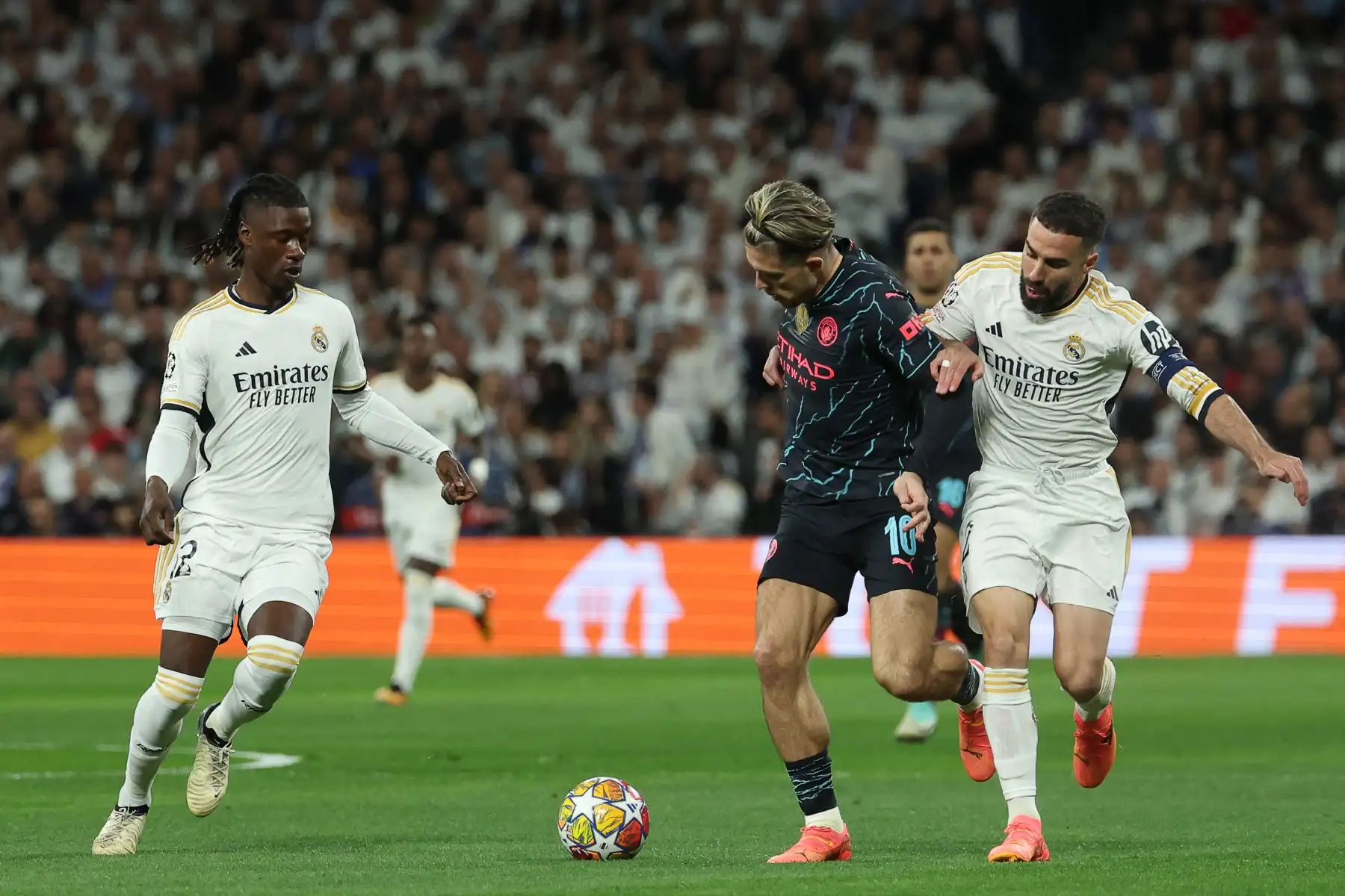 El centrocampista inglés del Manchester City, Jack Grealish, lucha por el balón con el defensor español del Real Madrid, Dani Carvajal, durante el partido de fútbol de ida de los cuartos de final de la Liga de Campeones de la UEFA entre el Real Madrid CF y el Manchester City en el estadio Santiago Bernabeu de Madrid el 9 de abril de 2024. Foto: AFP