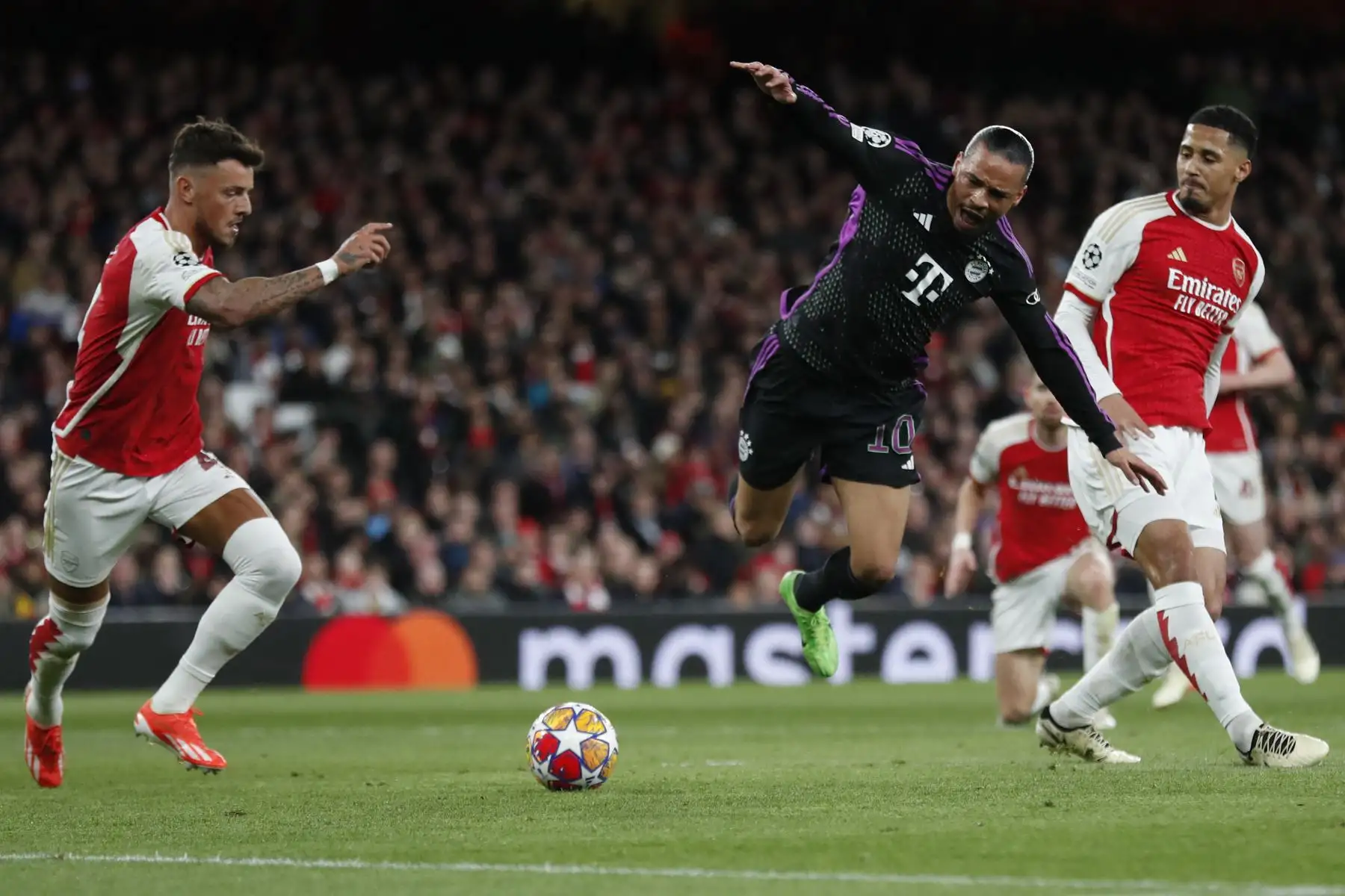 El defensor francés del Arsenal,  William Saliba lucha por el balón con el centrocampista alemán del Bayern Munich, Leroy Sane  durante el partido de fútbol de ida de los cuartos de final de la Liga de Campeones de la UEFA entre el Arsenal y el Bayern Munich en el estadio del Arsenal, en el norte. Londres.
Foto: AFP