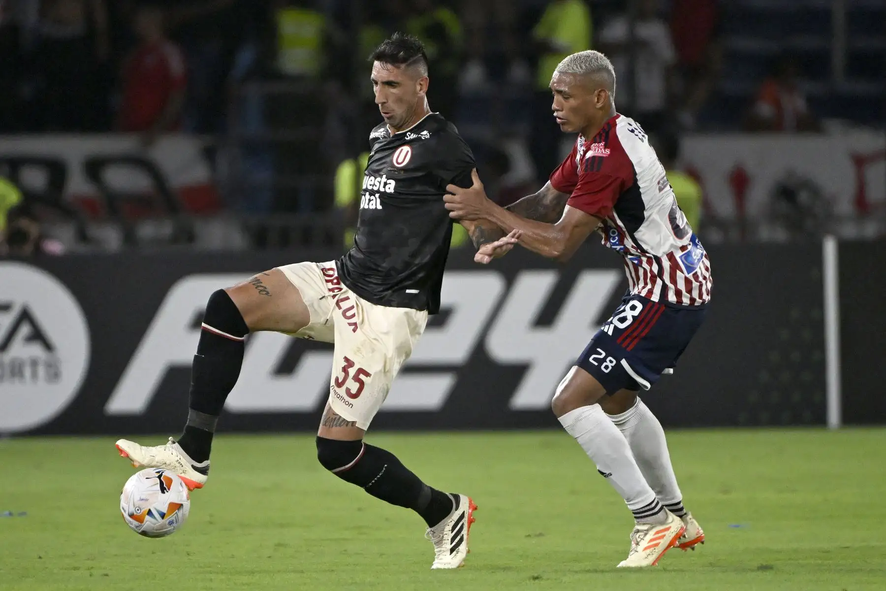 El delantero argentino de Universitario, Diego Dorregaray , y el defensor de Junior, Jermein Peña, luchan por el balón durante el partido de fútbol de ida de la fase de grupos de la Copa Libertadores entre Junior de Colombia y Universitario de Perú en el estadio Metropolitano Roberto Meléndez de Barranquilla.
Foto: AFP