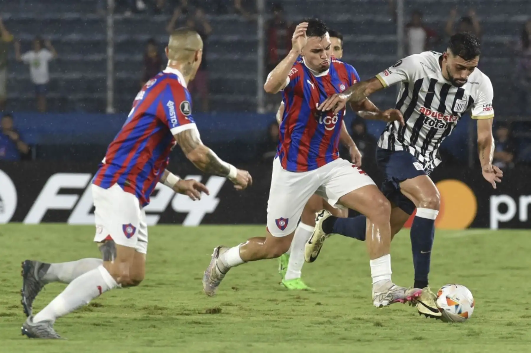El mediocampista de Cerro Porteño, Fabrizio Peralta (C), y el defensor argentino de Alianza Lima, Juean Freytes, luchan por el balón durante el partido de ida de la fase de grupos de la Copa Libertadores entre Cerro Porteño de Paraguay y Alianza Lima de Perú en el estadio La Nueva Olla de Asunción. Foto: AFP