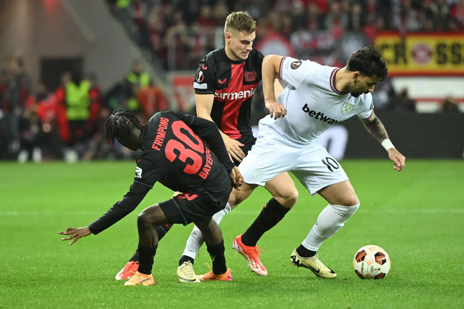 El centrocampista brasileño del West Ham United Lucas Paqueta compite por el balón con el defensor holandés Jeremie Frimpong del Bayer Leverkusen y el defensor croata Josip Stanisic del Bayer Leverkusen durante el partido de fútbol de ida de cuartos de final de la UEFA Europa League entre Bayer 04 Leverkusen y West Ham United FC en Leverkusen, oeste de Alemania. Foto: ANDINA/AFP