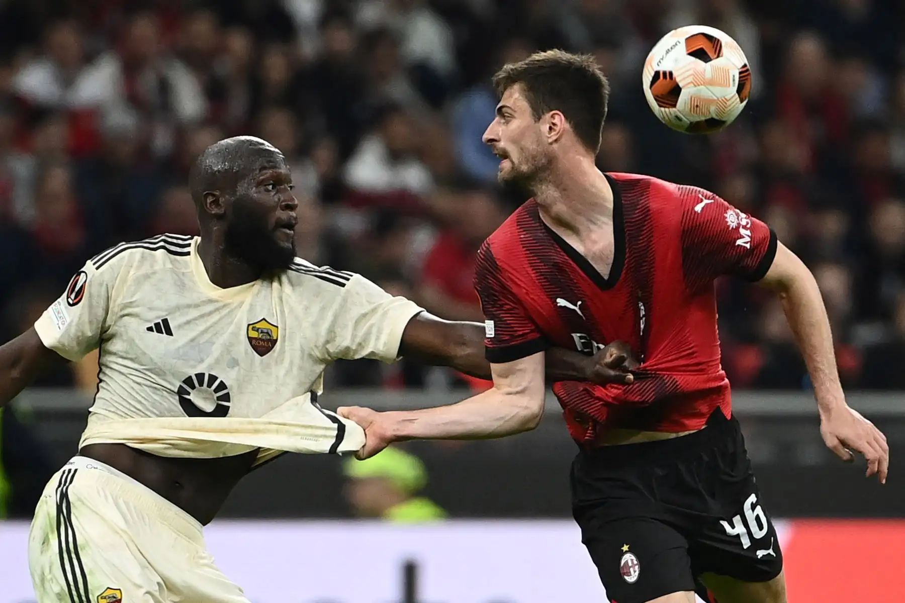 El centrocampista belga de Roma Romelu Lukaku  lucha por el balón con el defensor italiano del AC Milan  Matteo Gabbia durante el partido de fútbol de la Liga Europea de la UEFA entre el AC Milan y el AS Roma en el estadio de San Siro, en Milán. Foto: ANDINA/AFP