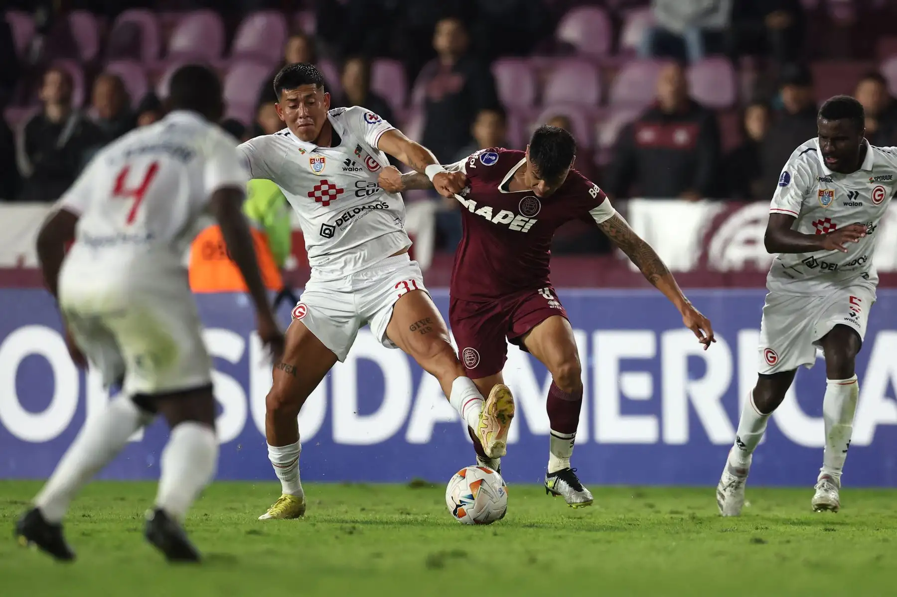 El mediocampista del Deportivo Garcilaso, Erick Gonzales, y el delantero de Lanús, Walter Bou, luchan por el balón durante el partido de ida de la fase de grupos de la Copa Sudamericana entre el Lanús de Argentina y el Deportivo Garcilaso de Perú en el Estadio La Fortaleza en Lanús, Provincia de Buenos Aires. Foto: ANDINA/AFP