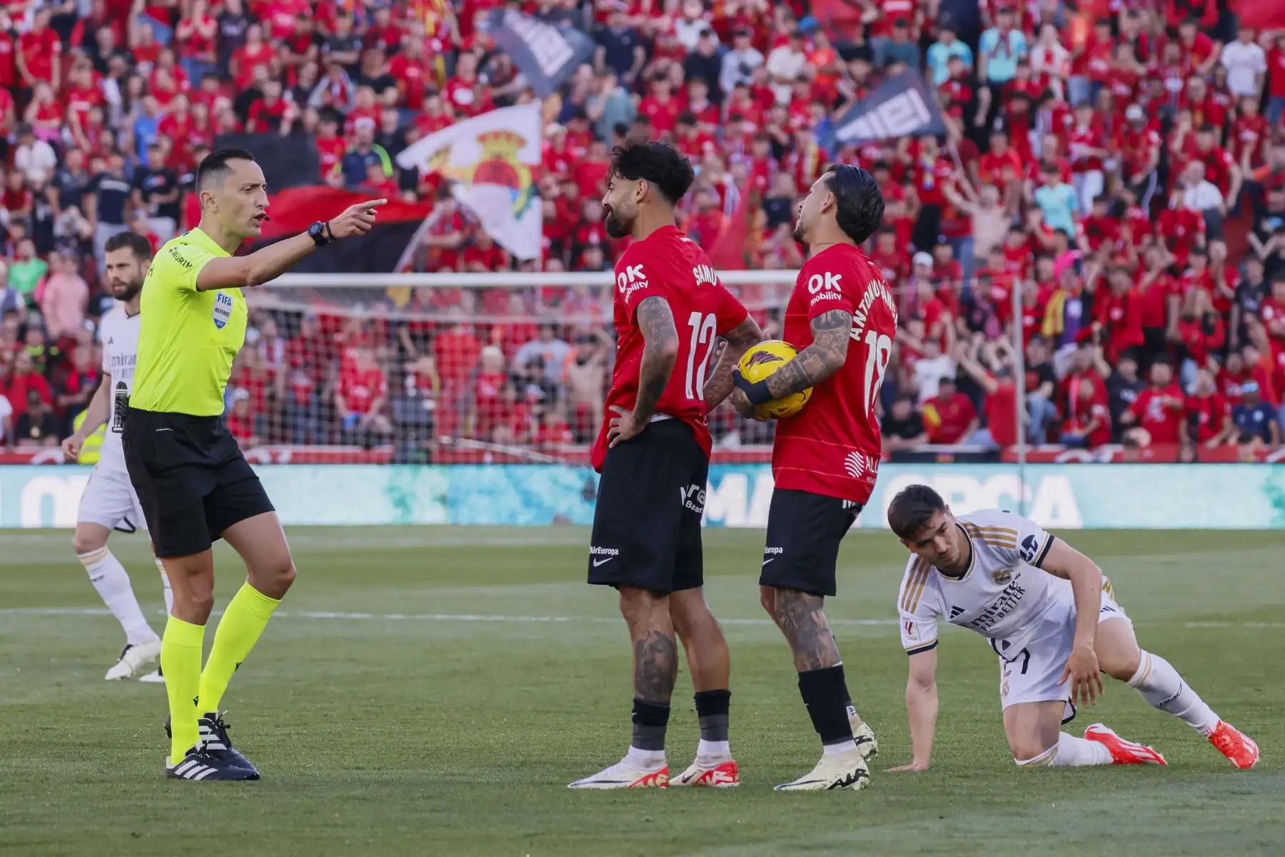 El colegiado Sánchez Martínez ante la protesta de los jugadores del Mallorca por una falta cometida sobre el centrocampista del Real Madrid, Brahim Díaz, durante el encuentro correspondiente a la jornada 31 de primera división que disputan Mallorca y Real Madrid. Foto: ANDINA/ EFE
