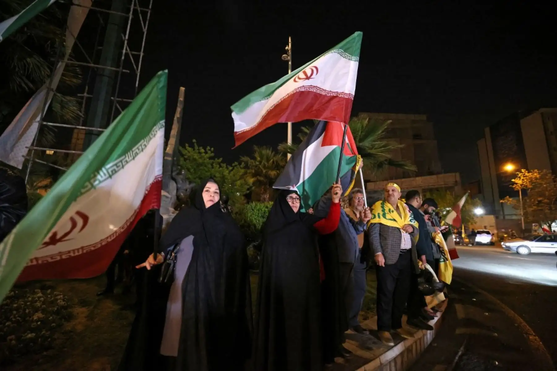 Manifestantes ondean la bandera de Irán y las banderas palestinas mientras se reúnen en la Plaza Palestina en Teherán después de que Irán lanzara un ataque con aviones no tripulados y misiles contra Israel. Foto: AFP