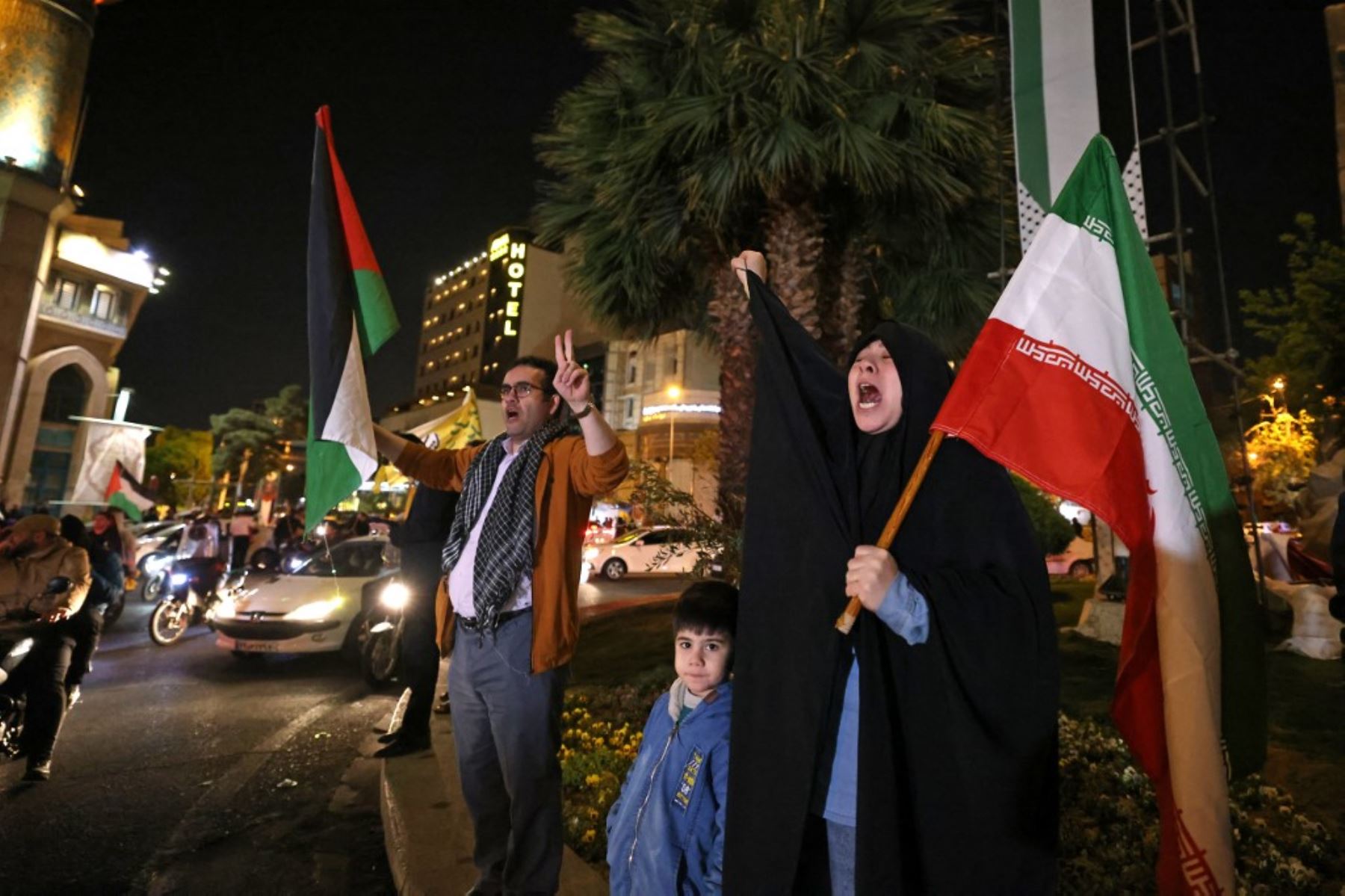 Manifestantes ondean la bandera de Irán y las banderas palestinas mientras se reúnen en la Plaza Palestina en Teherán después de que Irán lanzara un ataque con aviones no tripulados y misiles contra Israel. Foto: AFP