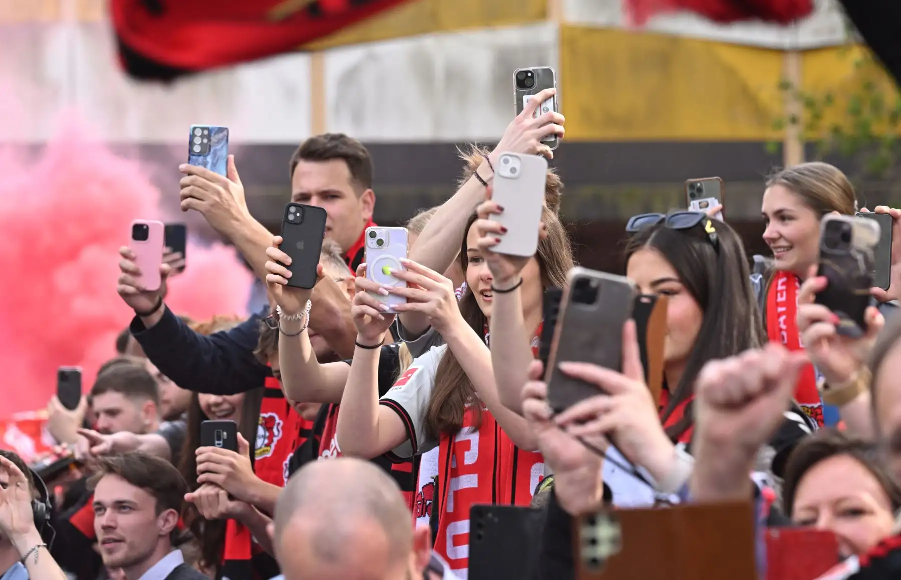Los aficionados del Bayer Leverkusen sostienen sus teléfonos móviles mientras el autobús que transporta a los jugadores llega antes del partido de fútbol de la primera división de la Bundesliga alemana Bayer 04 Leverkusen contra Werder Bremen. 
Foto: ANDINA/ AFP
