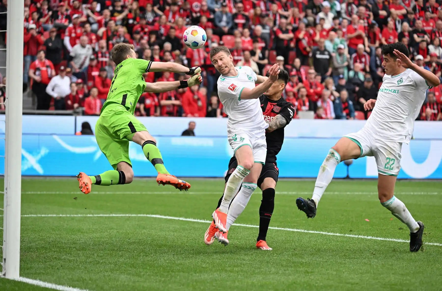 El defensor argentino de Bremen Julian Malatini intenta anotar un cabezazo ante el portero finlandés  del Bayer Leverkusen Lukas Hradecky durante el partido de fútbol de la primera división alemana de la Bundesliga Bayer 04 Leverkusen contra Werder Bremen. Foto: ANDINA/AFP
