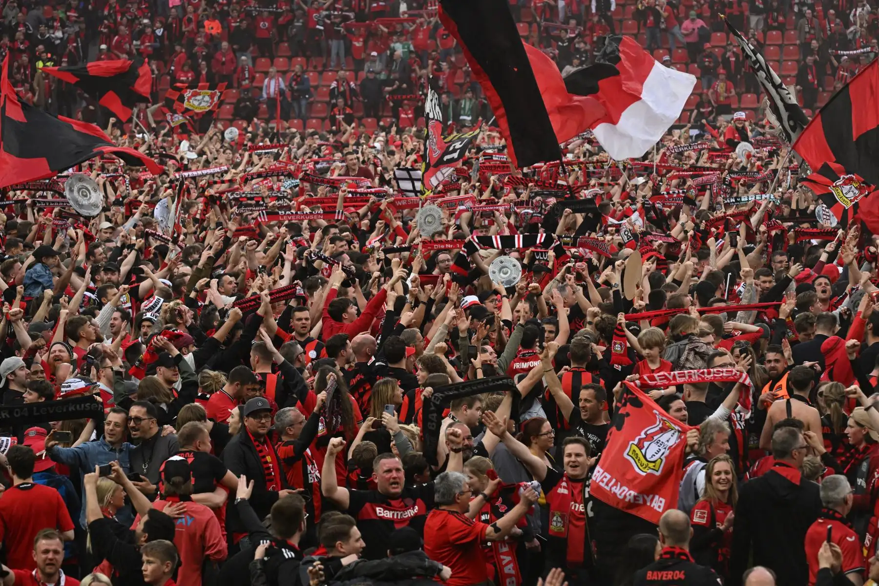 Los aficionados de Leverkusen celebran en el campo después del partido de fútbol de la primera división alemana de la Bundesliga Bayer 04 Leverkusen contra Werder Bremen en Leverkusen, Alemania occidental. Foto: ANDINA/AFP