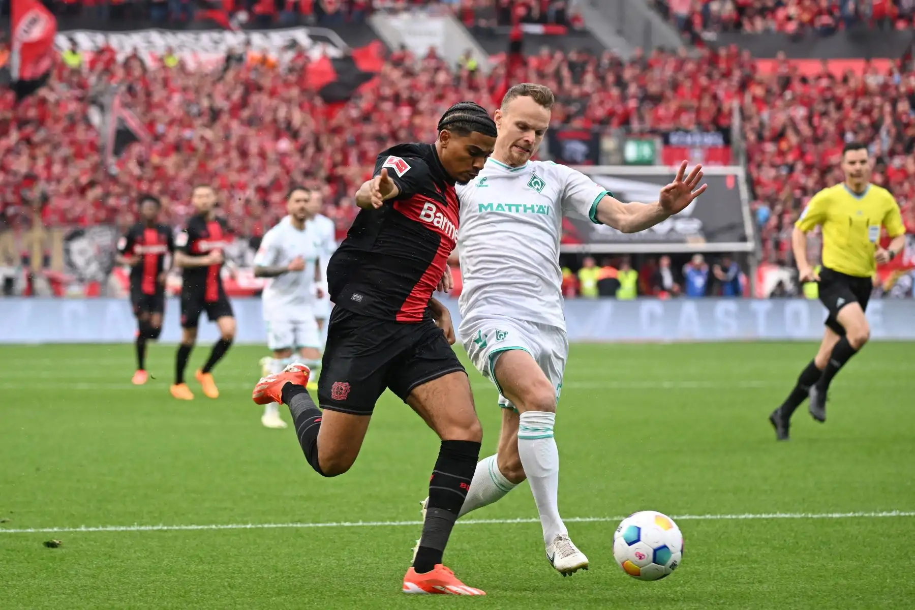 El delantero francés de Bayer Leverkusen Amine Adli y el defensor alemán de Bremen Christian Gross compiten por el balón durante el partido de fútbol de la primera división alemana de la Bundesliga Bayer 04 Leverkusen contra Werder Bremen. Foto: ANDINA/AFP