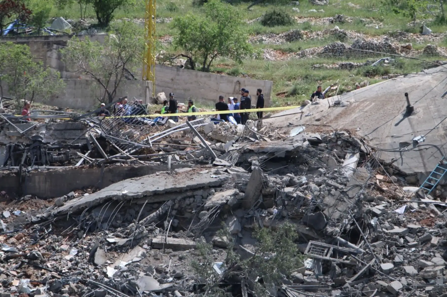 La gente se reúne alrededor de un edificio destruido por ataques aéreos israelíes en la aldea de Nabi Sheet en el distrito de Baablbek en el valle de Bekaa oriental del Líbano. Foto: AFP