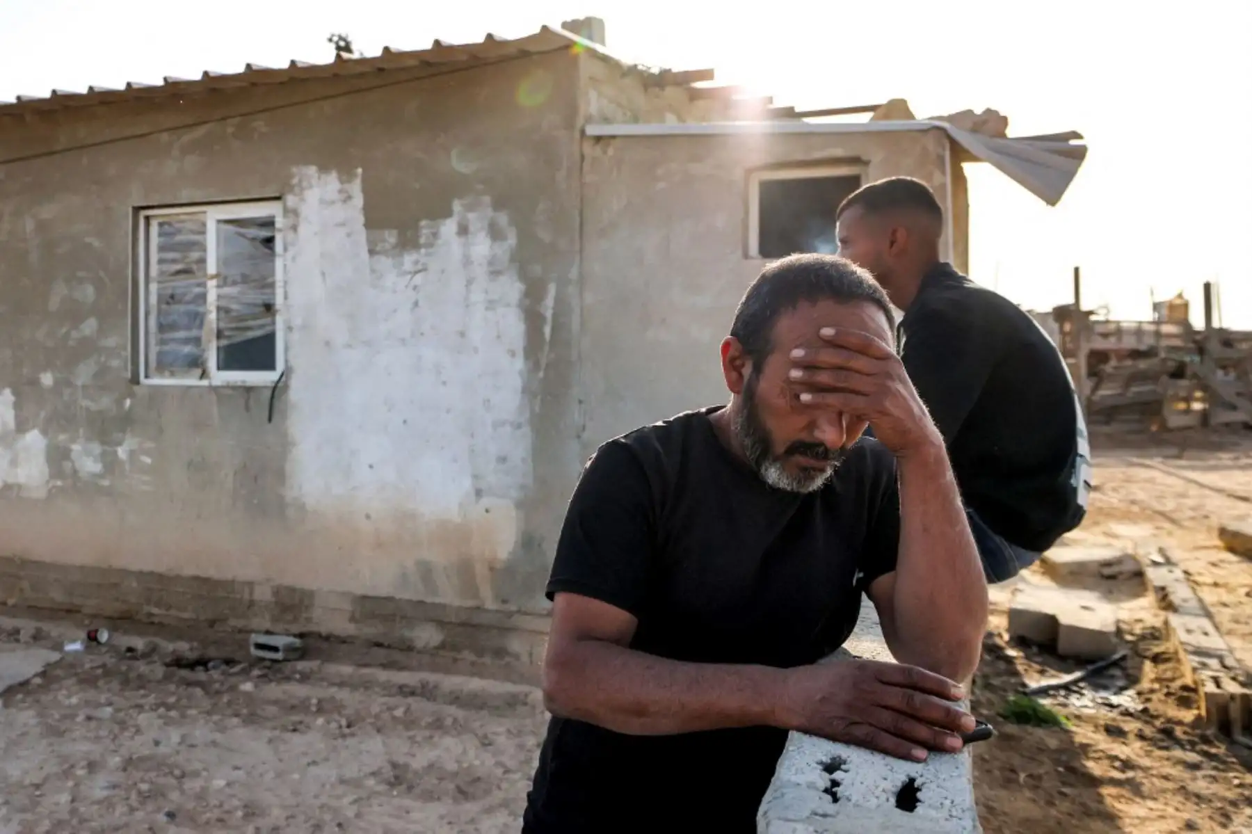 Mohamad Hassouna, de 49 años, reacciona frente a un edificio donde su hija Amina, de siete años, resultó herida por un proyectil entrante en su aldea beduina, no reconocida por las autoridades israelíes, en el sur del desierto de Negev el 14 de abril de 2024. Irán lanzó más de 300 drones y misiles hacia Israel en su ataque sin precedentes durante la noche, hiriendo al menos a 12 personas, dijo un portavoz del ejército israelí el 14 de abril. Foto: AFP