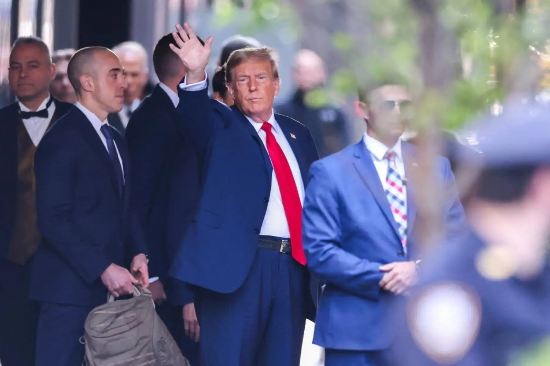 El expresidente estadounidense Donald Trump saluda mientras sale de la Torre Trump hacia el Tribunal Penal de Manhattan, para asistir al primer día de su juicio por supuestamente encubrir pagos de dinero vinculados a relaciones extramatrimoniales, en la ciudad de Nueva York. Foto: AFP