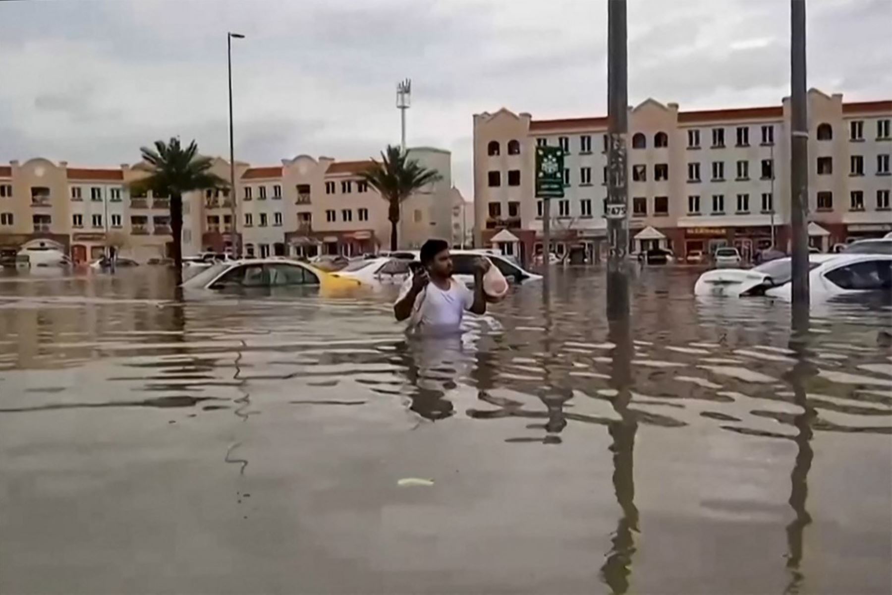 un hombre camina por una calle inundada en Dubai, el centro financiero de Oriente Medio, quedó paralizado por las lluvias torrenciales que provocaron inundaciones en los Emiratos Árabes Unidos y Bahréin y dejaron 18 muertos en Omán. Foto: AFP