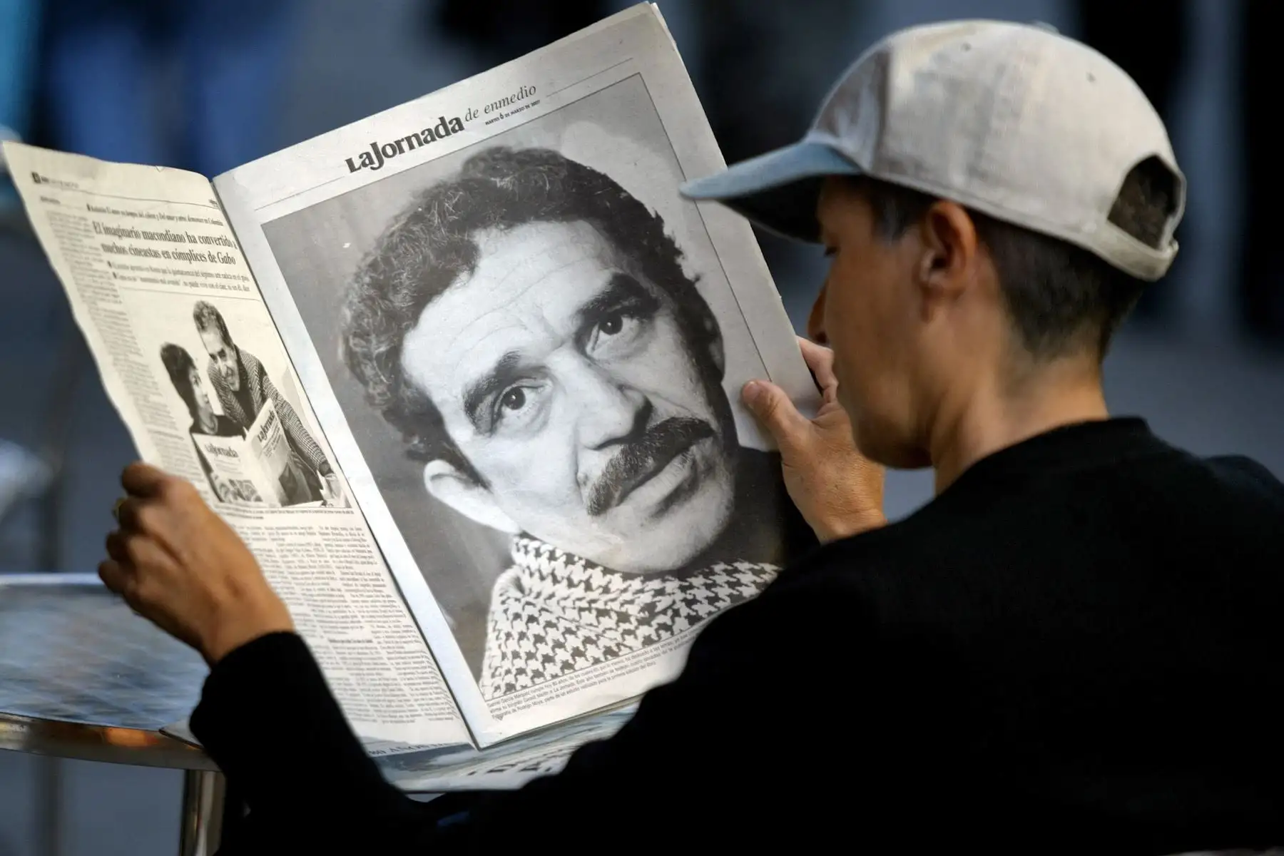 Un joven mexicano sentado en un café lee un periódico que ofrece un suplemento especial dedicado al escritor colombiano y Premio Nobel de Literatura 1982 Gabriel García Márquez en el día de su 80 aniversario, el 06 de marzo de 2007 en la Ciudad de México. 
Foto: AFP