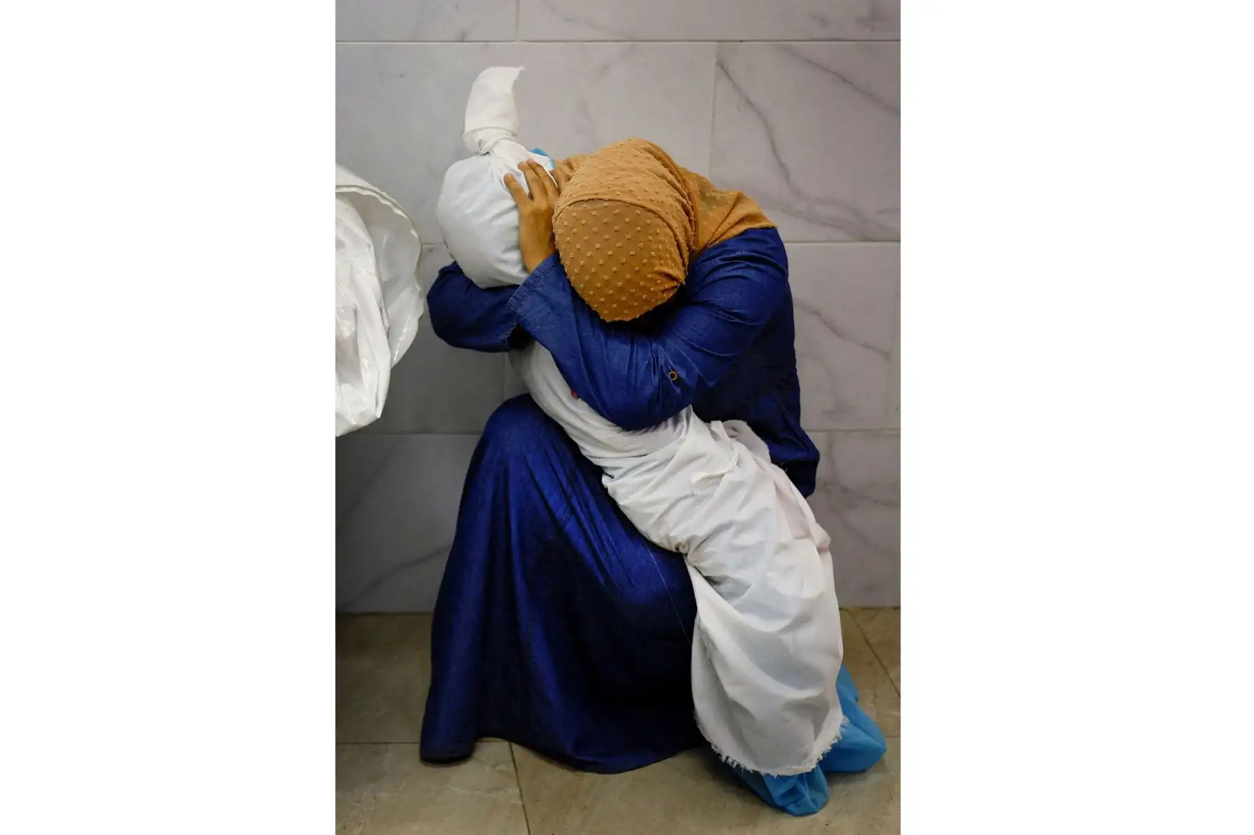 Foto ganadora del World Press Photo 2024. Inas Abu Maamar, de 36 años, abraza el cuerpo de su sobrina Saly, de cinco años, que murió, junto con otros cuatro miembros de la familia, cuando un misil israelí alcanzó su casa en Jan Yunis (Gaza), el 17 de octubre de 2023. El jurado destacó "el cuidado y respeto empleados a la hora de componer la imagen, que ofrece, al mismo tiempo, una mirada metafórica y literal sobre una pérdida inimaginable".
MOHAMMED SALEM (REUTERS)