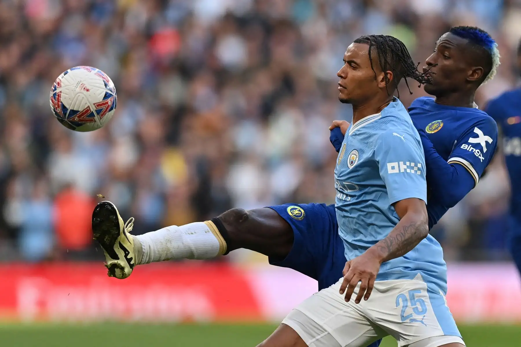 El defensor suizo del Manchester City Manuel Akanji compite con el delantero senegalés del Chelsea Nicolas Jackson durante el partido de fútbol semifinal de la Copa FA inglesa entre Manchester City y Chelsea. 
Foto: ANDINA/AFP