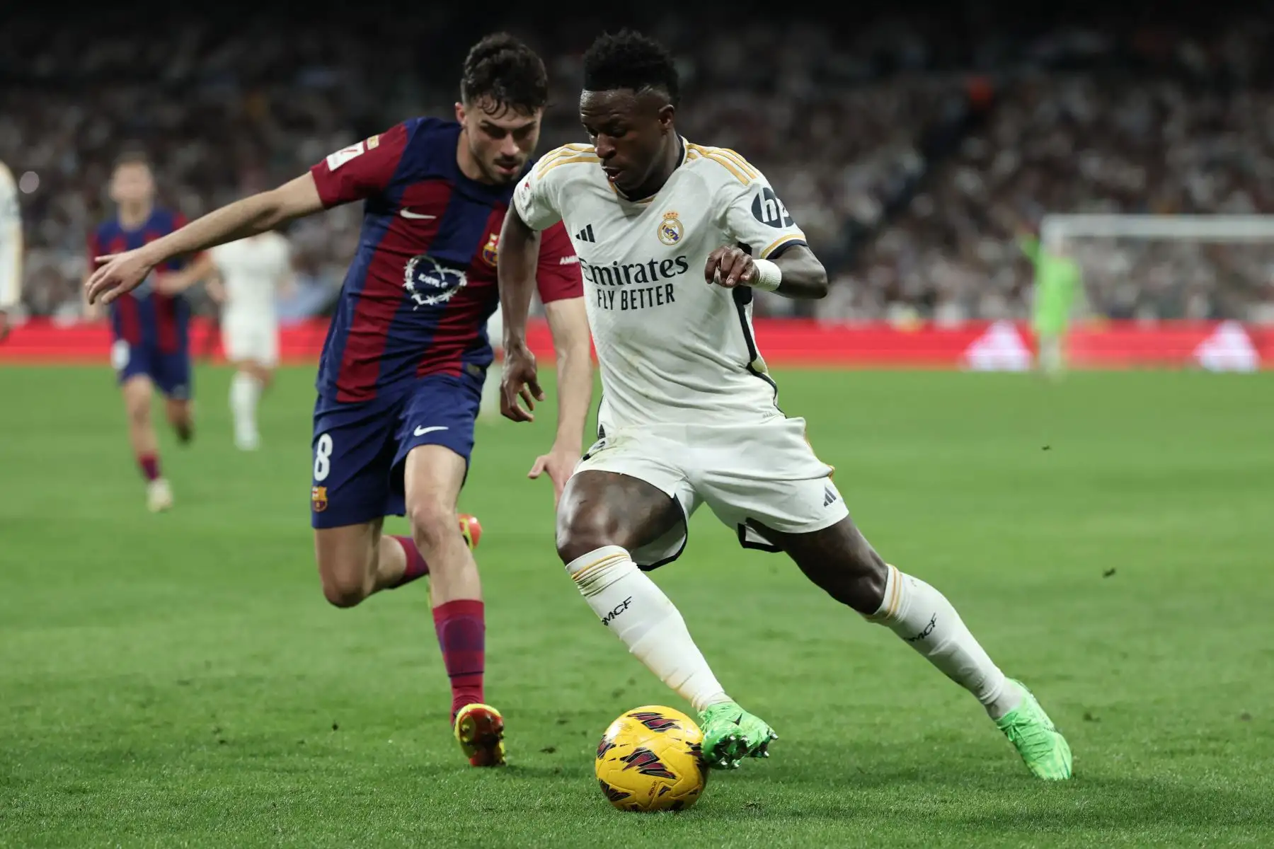 El delantero brasileño del Real Madrid, Vinicius Junior, lucha por el balón con el mediocampista español del Barcelona, Pedri, durante el partido de fútbol de la liga española entre el Real Madrid FC y el FC Barcelona en el estadio Santiago Bernabeu de Madrid el 21 de abril de 2024. Foto: AFP