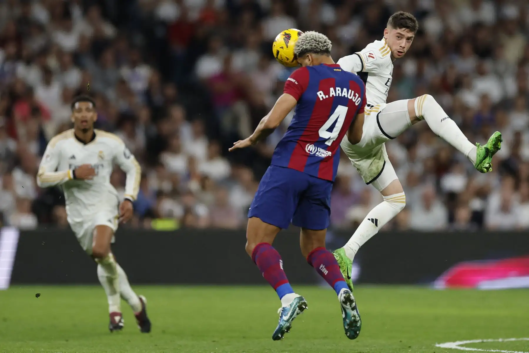 El defensor uruguayo del Barcelona, Ronald Araujo, y el mediocampista uruguayo del Real Madrid, Federico Valverde, compiten por el balón durante el partido de fútbol de la liga española entre el Real Madrid FC y el FC Barcelona en el estadio Santiago Bernabeu de Madrid el 21 de abril de 2024. Foto: AFP