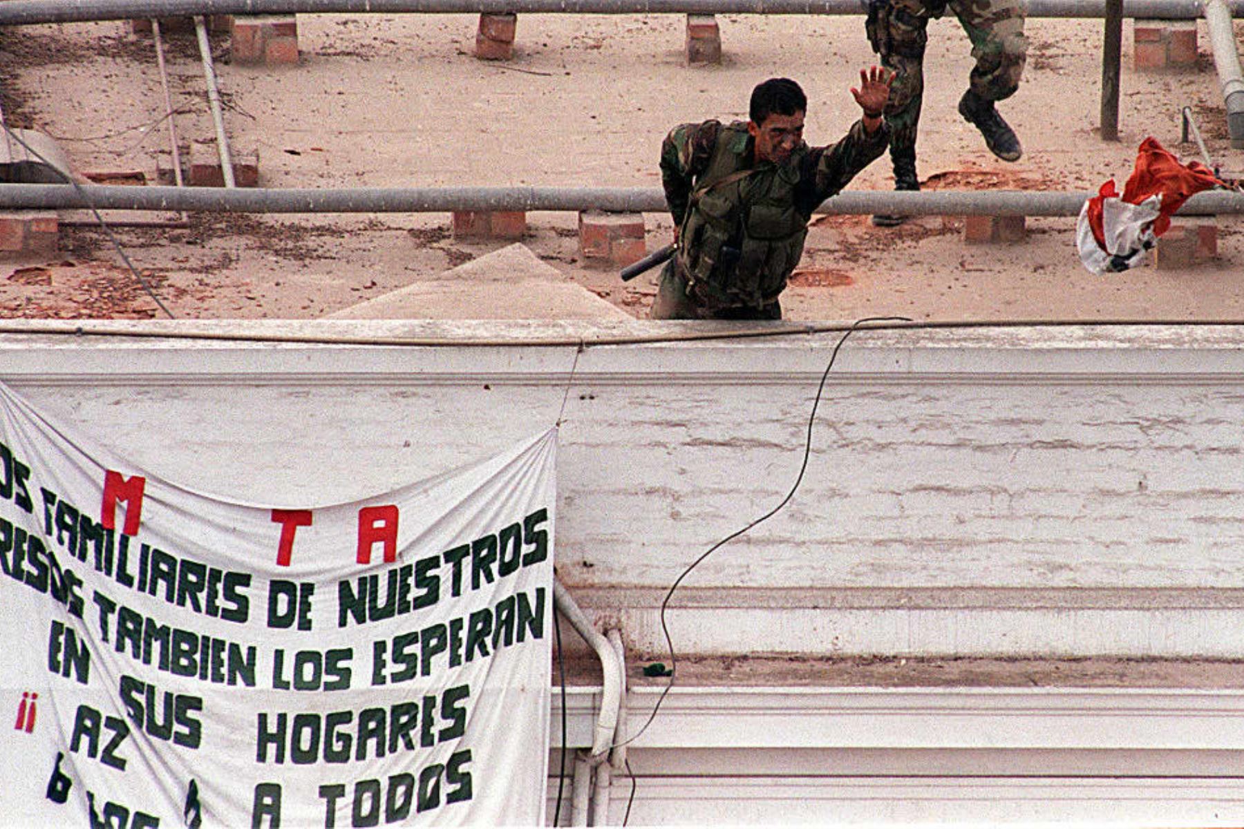Un miembro de las fuerzas especiales del ejército peruano arroja una de las banderas del grupo terrorista MRTA  desde el techo de la residencia del embajador japonés en Lima el 22 de abril, después de que 140 soldados irrumpieran en la residencia, liberando a los rehenes. Foto: AFP