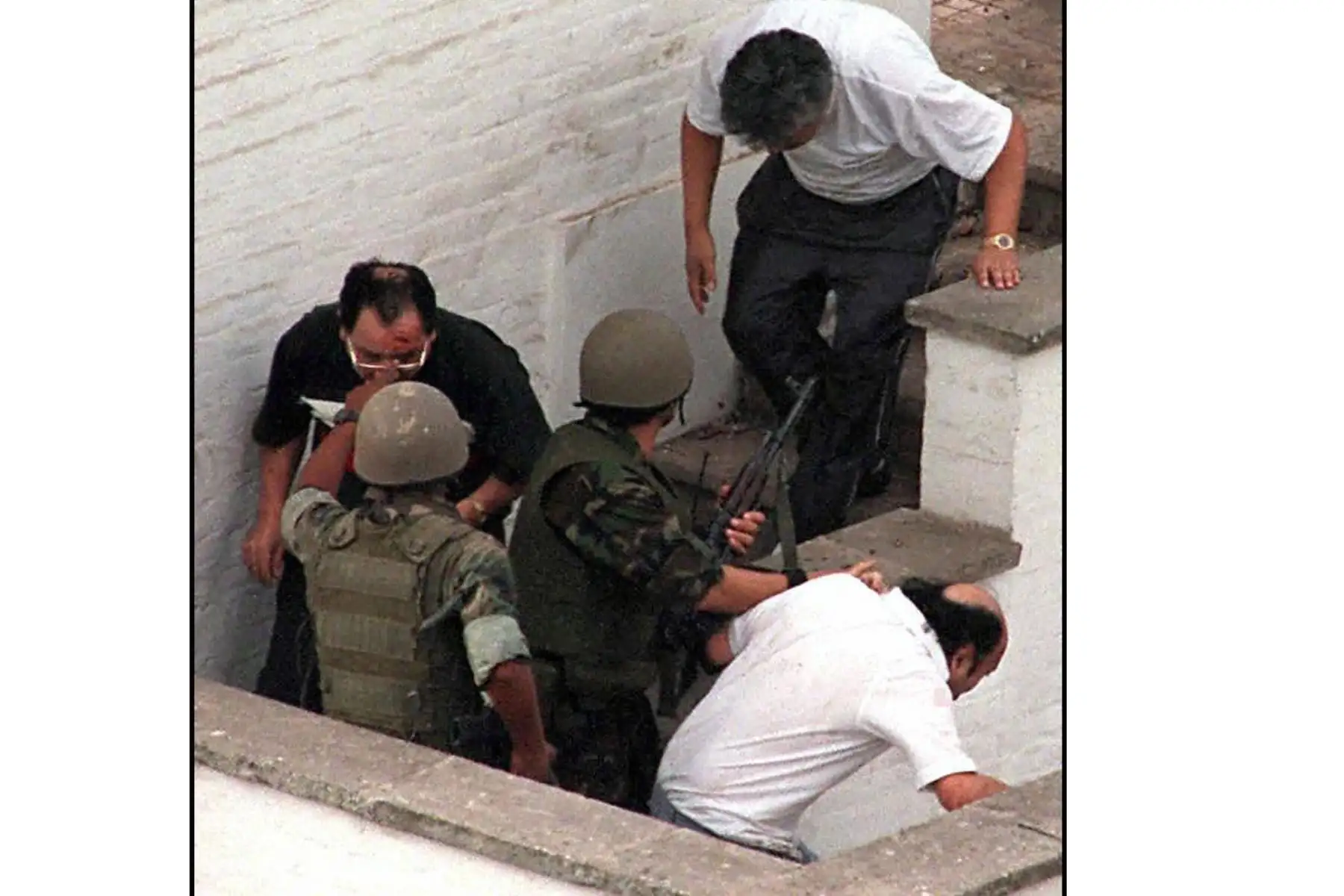 Miembros de las fuerzas especiales peruanas guían a un grupo de rehenes fuera de la residencia del embajador japonés durante la operación de rescate en Lima. Foto: AFP