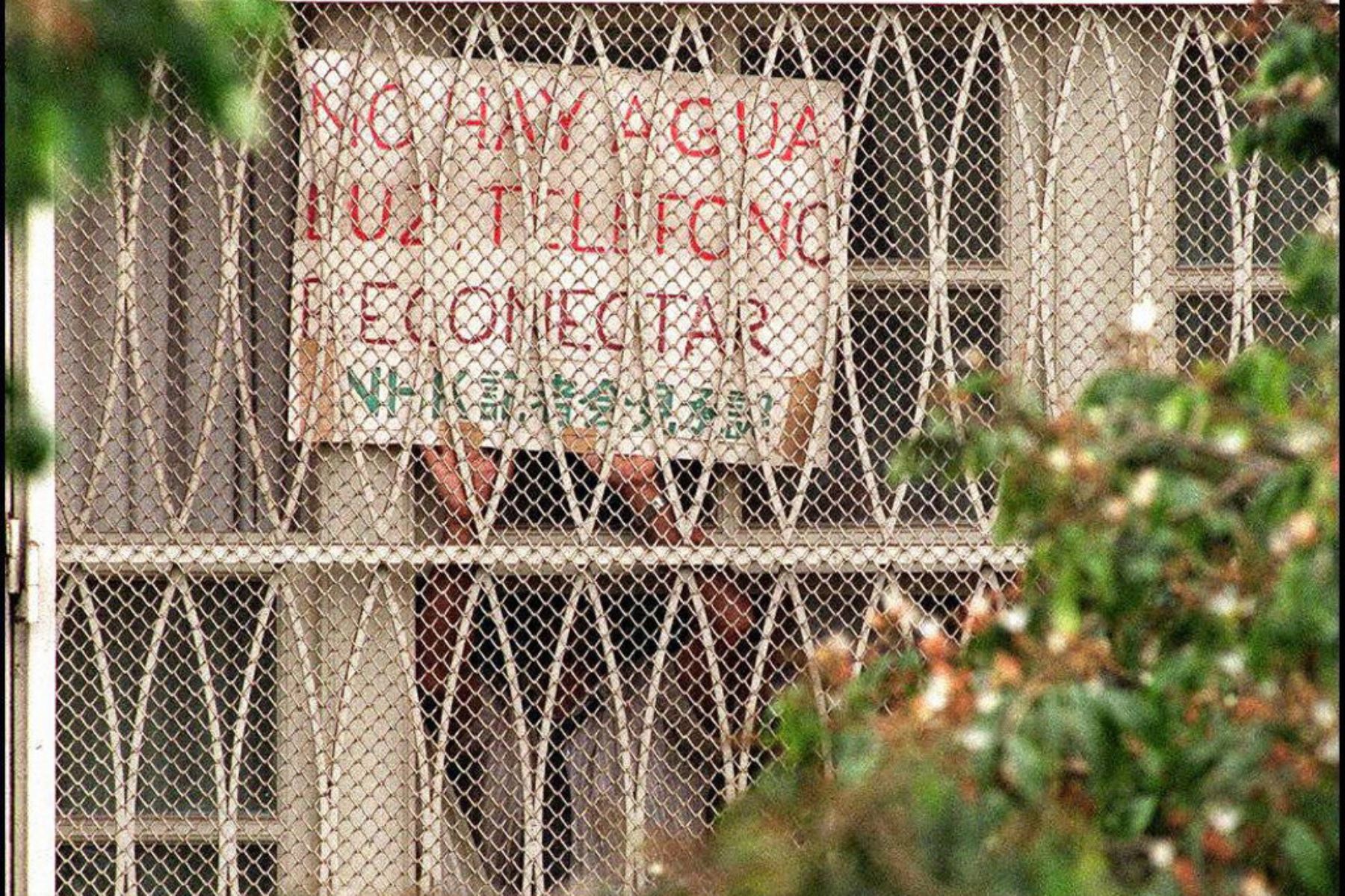 Alrededor de la residencia del embajador japonés en Lima sostiene un mensaje que dice "no hay agua, reconecten el teléfono y la electricidad". Foto: AFP
