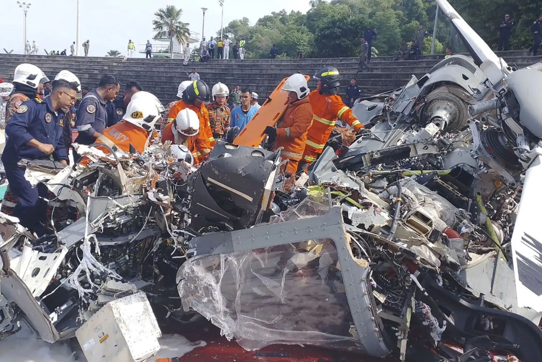 Fotografía proporcionada por el Departamento de Bomberos y Rescate de Perak muestra a oficiales del Departamento de Bomberos y Rescate de Malasia en el lugar donde dos helicópteros se estrellaron durante un ensayo, en la base de la Marina Real de Malasia. Foto: AFP