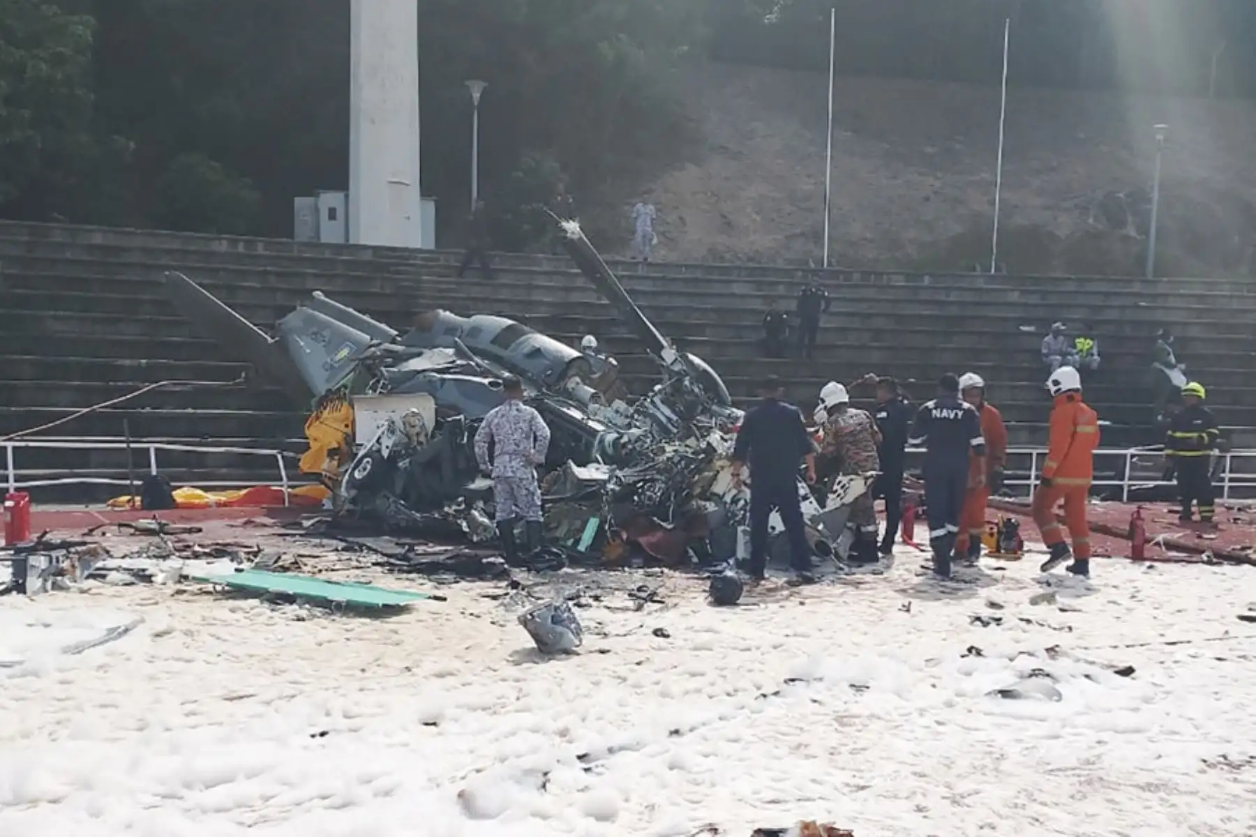 Fotografía proporcionada por el Departamento de Bomberos y Rescate de Perak muestra a oficiales del Departamento de Bomberos y Rescate de Malasia en el lugar donde dos helicópteros se estrellaron durante un ensayo, en la base de la Marina Real de Malasia. Foto: AFP