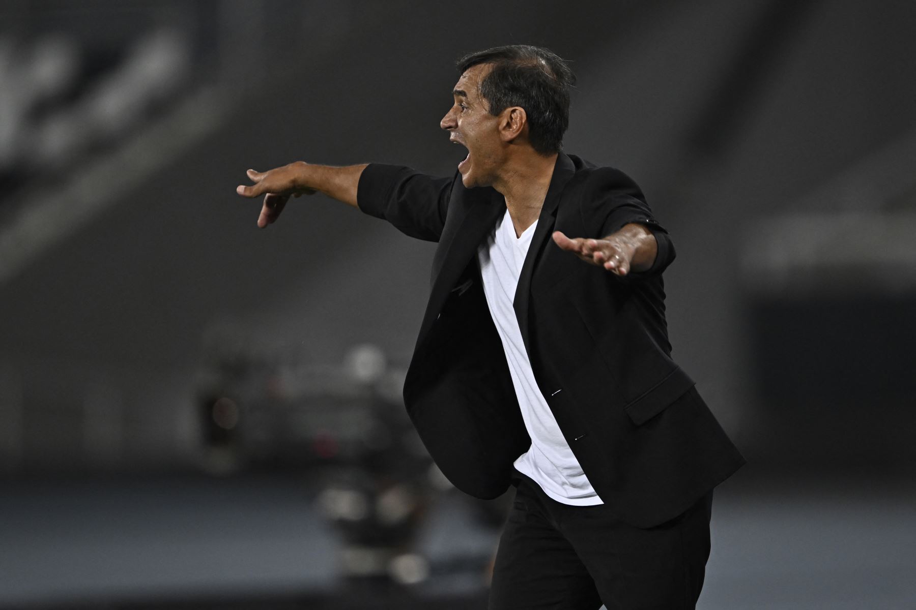 El entrenador argentino de Universitario, Fabián Bustos, hace gestos durante el partido de fútbol de ida de la fase de grupos de la Copa Libertadores entre el Botafogo de Brasil y el Universitario de Perú en el estadio Nilton Santos de Río de Janeiro, Brasil, el 24 de abril de 2024. Foto: AFP