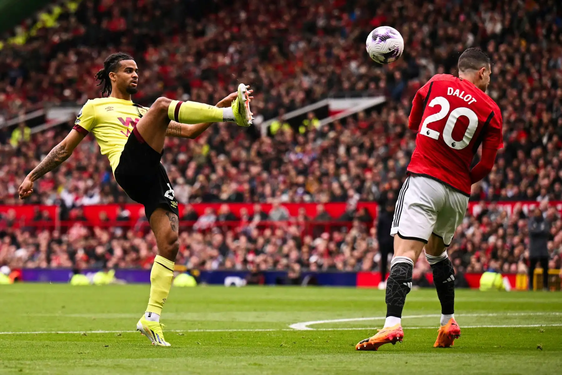El defensor francés del Burnley  Lorenz Assignon dispara el balón pasando al defensor portugués del Manchester United Diogo Dalot durante el partido de fútbol de la Premier League inglesa entre Manchester United y Burnley. 
 Foto: ANDINA/AFP