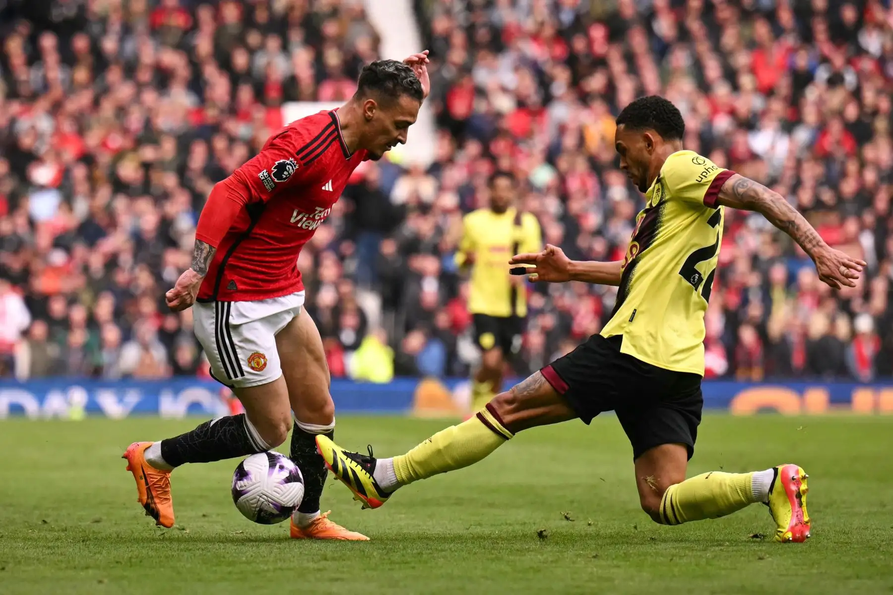 El centrocampista brasileño del Manchester United Antony  lucha por el balón con el defensor brasileño del Burnley  Vitinho durante el partido de fútbol de la Premier League inglesa entre Manchester United y Burnley. Foto: ANDINA/AFP