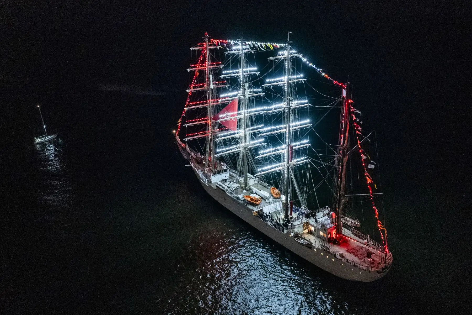 El Buque escuela B.A.P. Unión luce imponente frente a la costa de Chorrillos iluminado de rojo y blanco. Un gran espectáculo de fuegos artificiales le dio la bienvenida tras recorrer 36,400 millas náuticas y 317 días de viaje. Foto: Cortesía/Cristian Olea