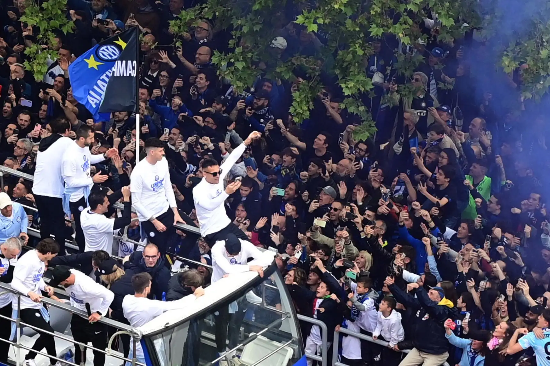 El delantero argentino  del Inter de Milán, Lautaro Martínez, celebra con sus compañeros y el personal mientras desfilan en autobuses para celebrar el 