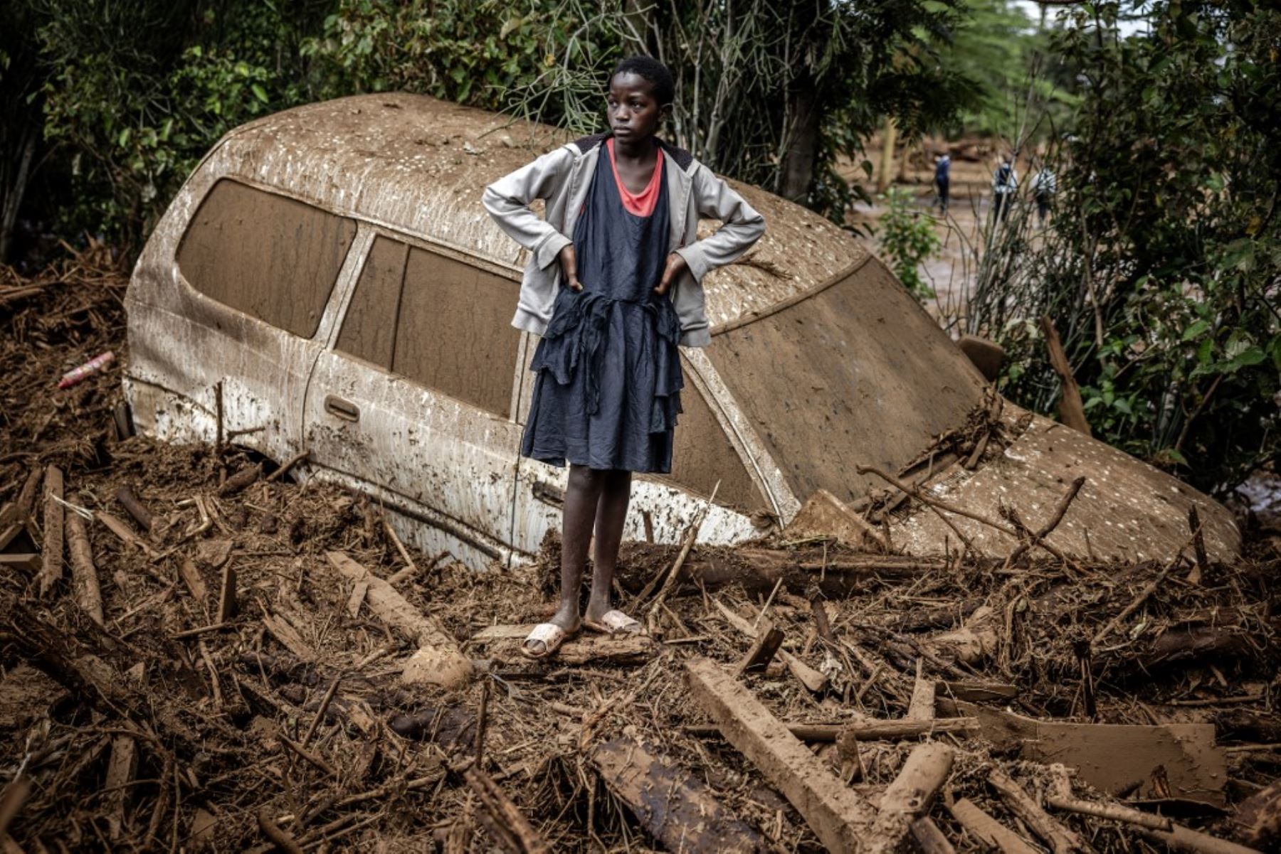 Una niña observa junto a un coche averiado enterrado en barro en una zona muy afectada por lluvias torrenciales e inundaciones repentinas en la aldea de Kamuchiri, cerca de Mai Mahiu. Al menos 45 personas murieron cuando una presa se desbordó. cerca de una ciudad en el Valle del Rift de Kenia. Foto: AFP