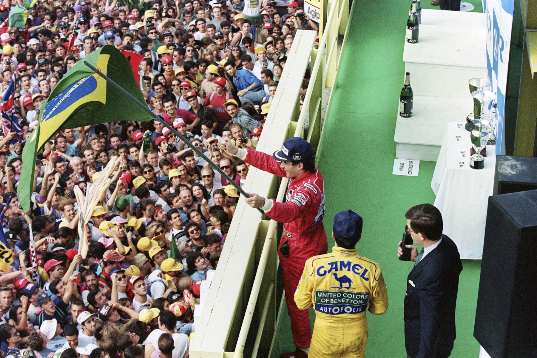El piloto brasileño de Fórmula Uno Ayrton Senna  sostiene una bandera brasileña y saluda a la multitud después del Gran Premio de Italia en Monza, el 13 de septiembre de 1992. 
Foto: AFP