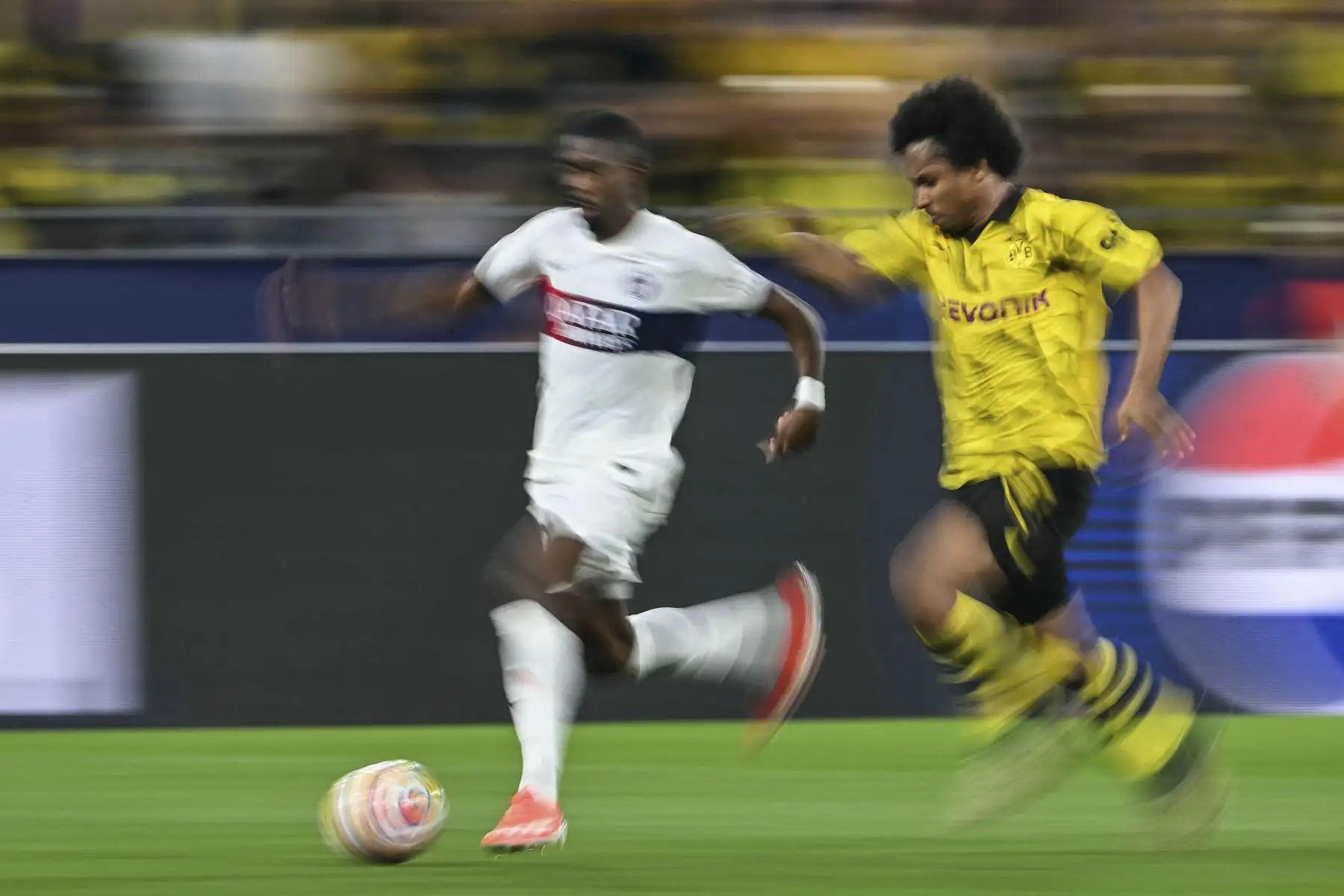 El delantero francés #10 del Paris Saint-Germain, Ousmane Dembele, es perseguido por el delantero alemán #27 del Dortmund Karim Adeyemi durante el partido de fútbol de ida de la semifinal de la Liga de Campeones de la UEFA entre el Borussia Dortmund y el Paris Saint-Germain 

Foto: AFP