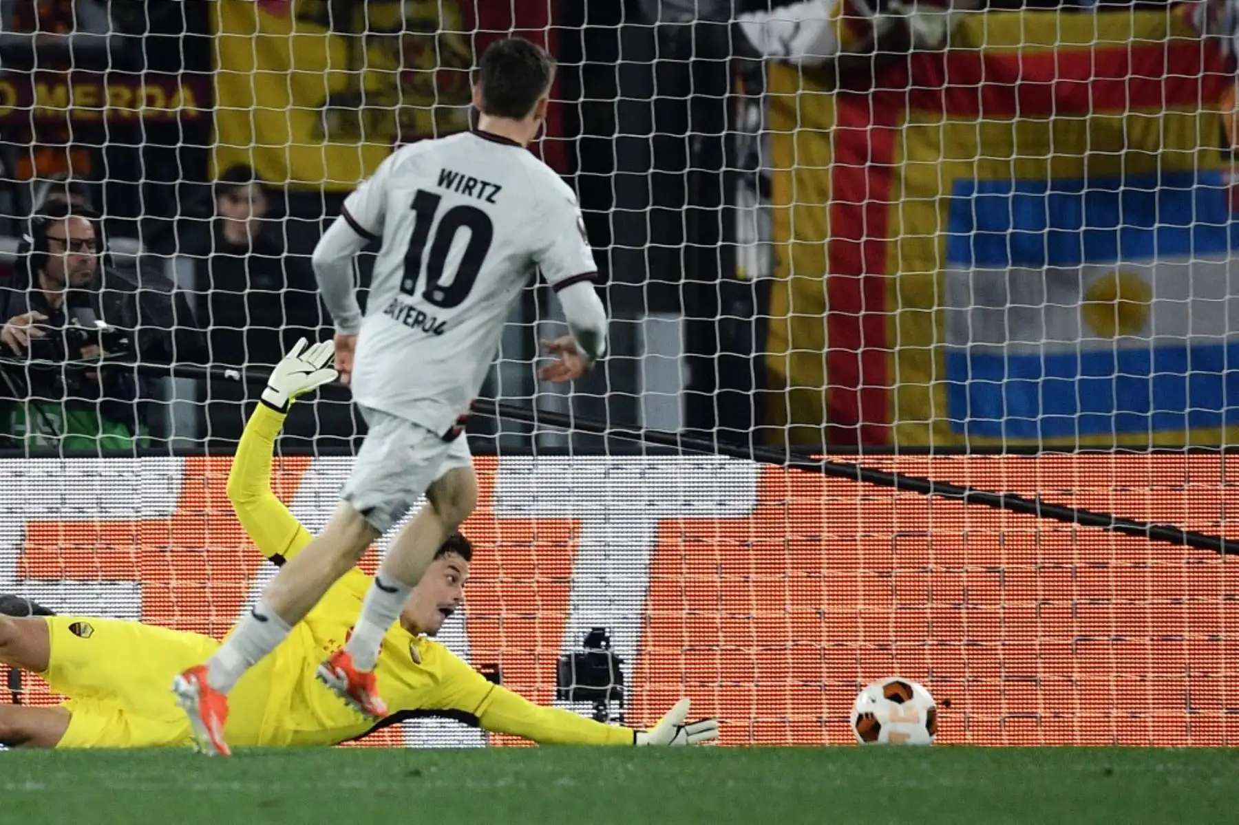 El centrocampista alemán #10 del Bayer Leverkusen, Florian Wirtz, anota el primer gol de su equipo contra el portero serbio #99 Mile Svilar de la Roma durante el partido de fútbol de ida de la semifinal de la UEFA Europa League entre AS Roma y Bayer Leverkusen en el estadio olímpico el 2 de mayo de 2024 en Roma. Foto: AFP