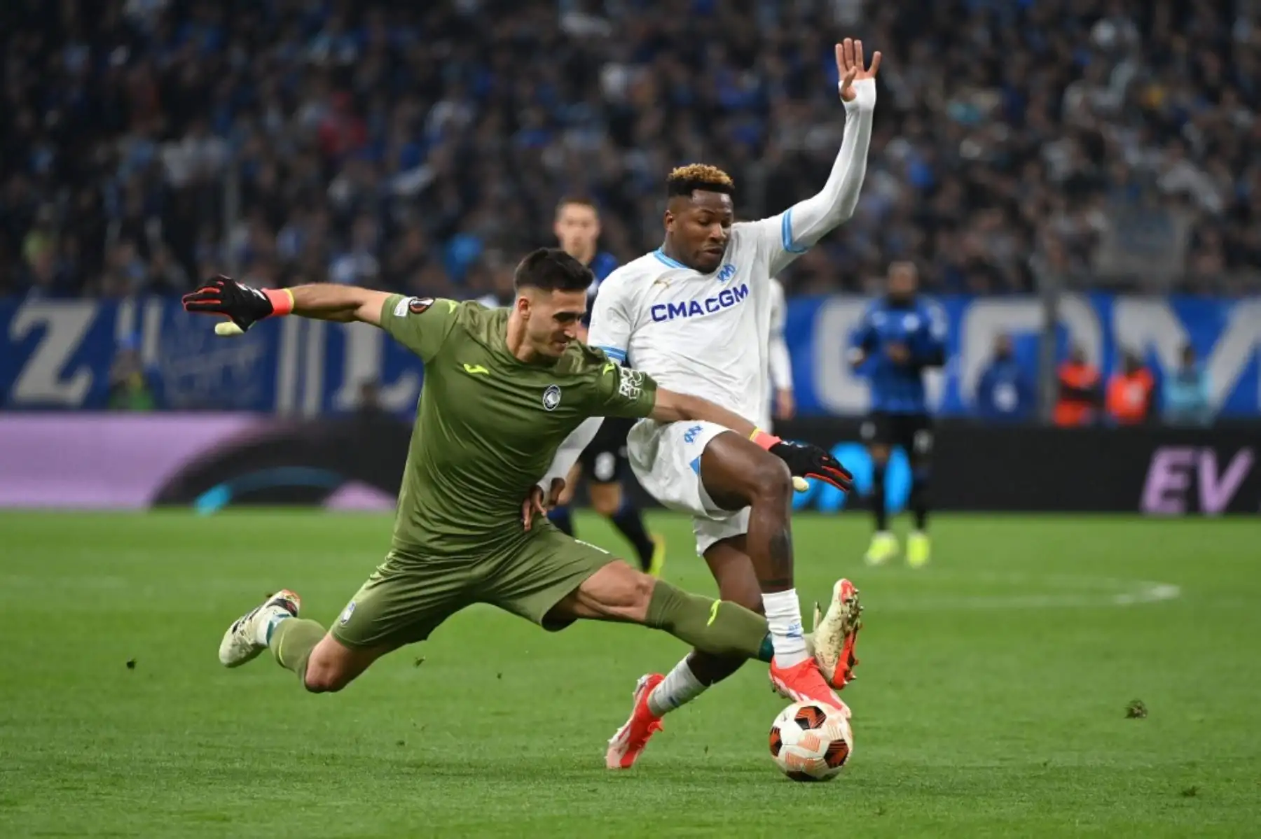El portero argentino de Atalanta #01 Juan Musso (L) y el delantero camerunés de Marsella #14 Faris Moumbagna (R) luchan por el balón durante el partido de fútbol de ida de semifinales de la UEFA Europa League entre Olympique de Marseille (OM) y Atalanta en el Stade Velódromo en Marsella, sur de Francia, el 2 de mayo de 2024. Foto: AFP